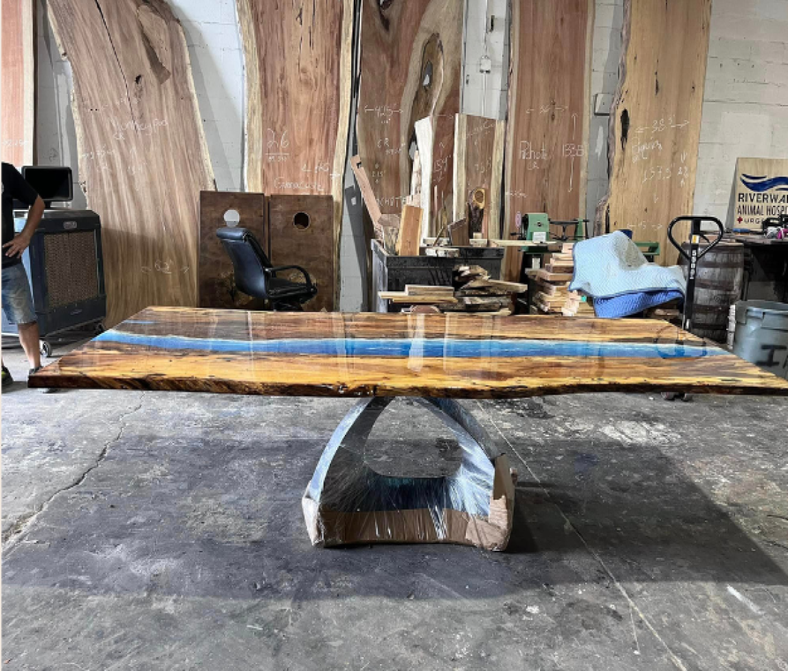 Premium epoxy resin pored wood dinning room table. Ocean like scene running down the middle of a beautiful wood slab.