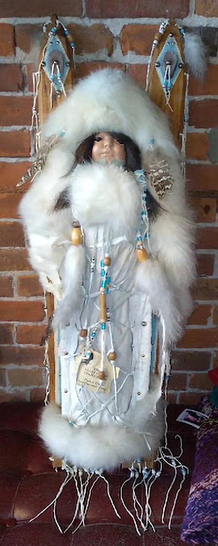 Little Snow Princess, by Coyote Woman Co., Porcelain Doll, dressed with White Fox, on a papoose with beads, leather, feathers, 53/200, $250