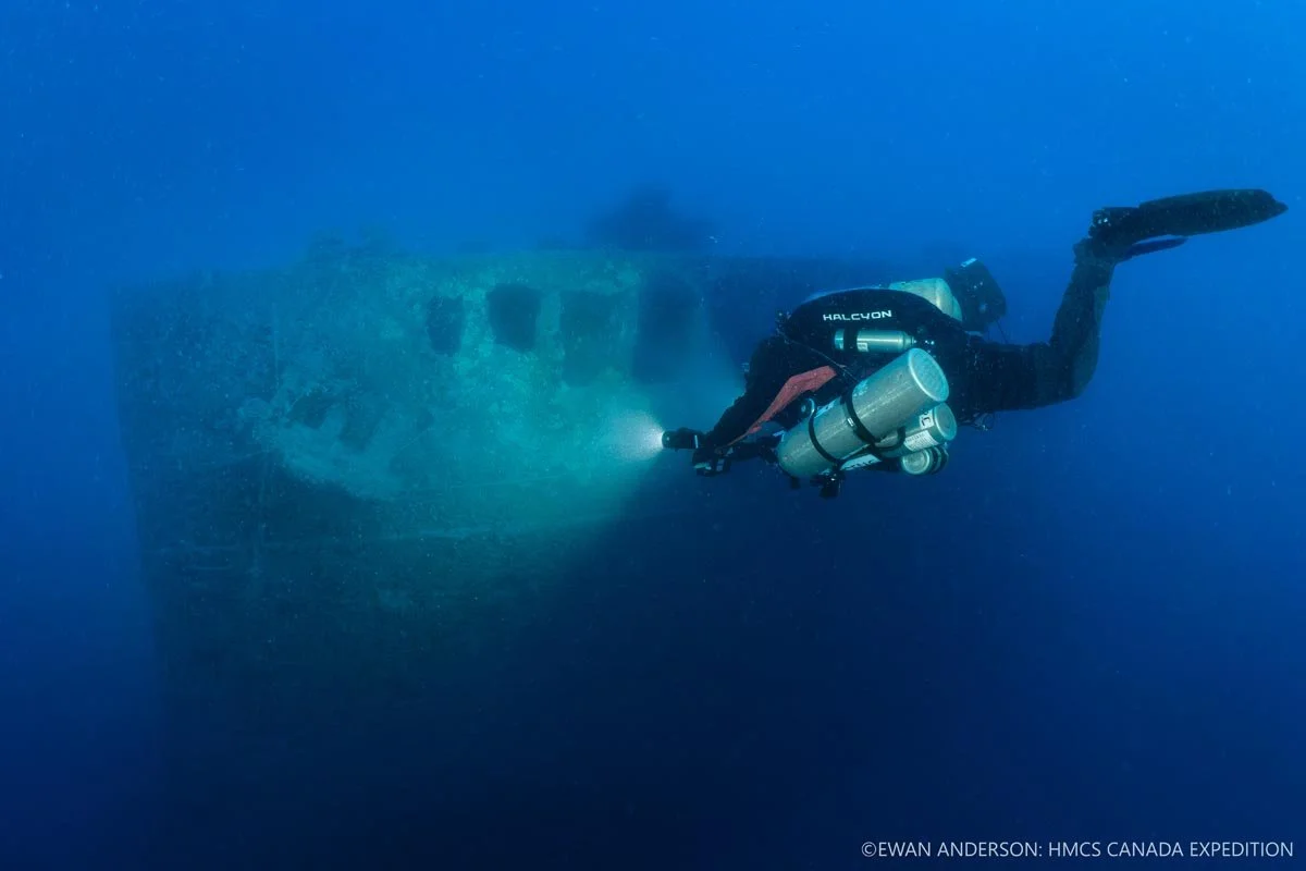 Diver Jason Cook illuminates the bow and port-side anchor of HMCS Canada.