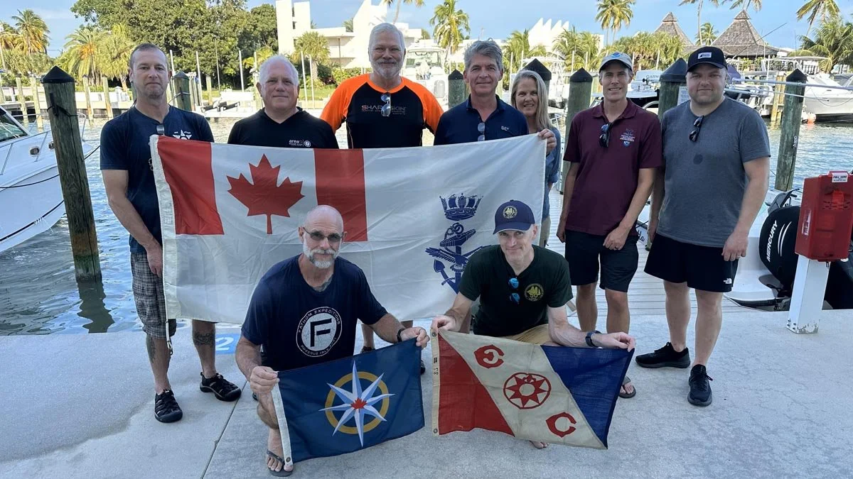 Group photograph. Front row (left to right): Kelvin Davidson (with RCGS expedition flag),
Ewan Anderson (with Explorers Club expedition flag). Back row (left to right): Rob DeProy, Guy Shockey, Joseph Frey, Roger Lacasse, Brenda Altmeier (NOAA), Matt
