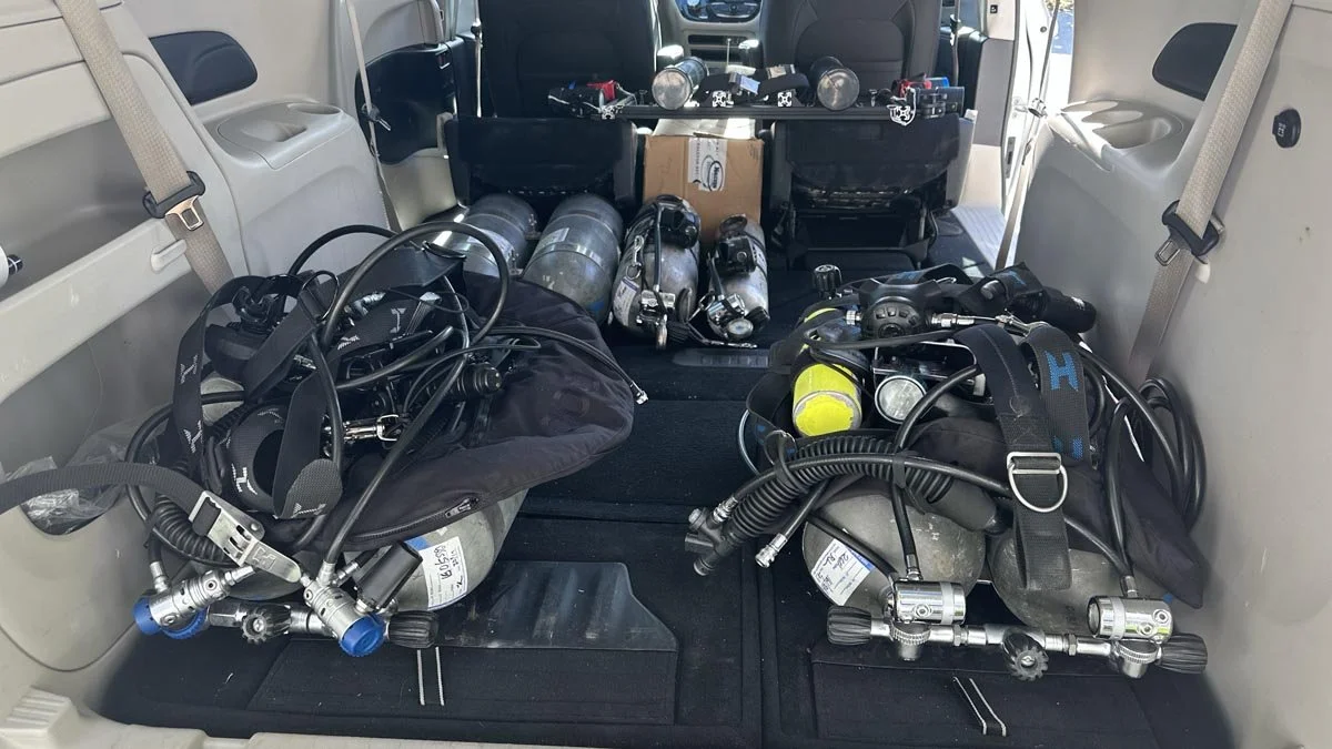 Unloading one of four vans and SUVs of dive equipment on the first morning of the expedition.