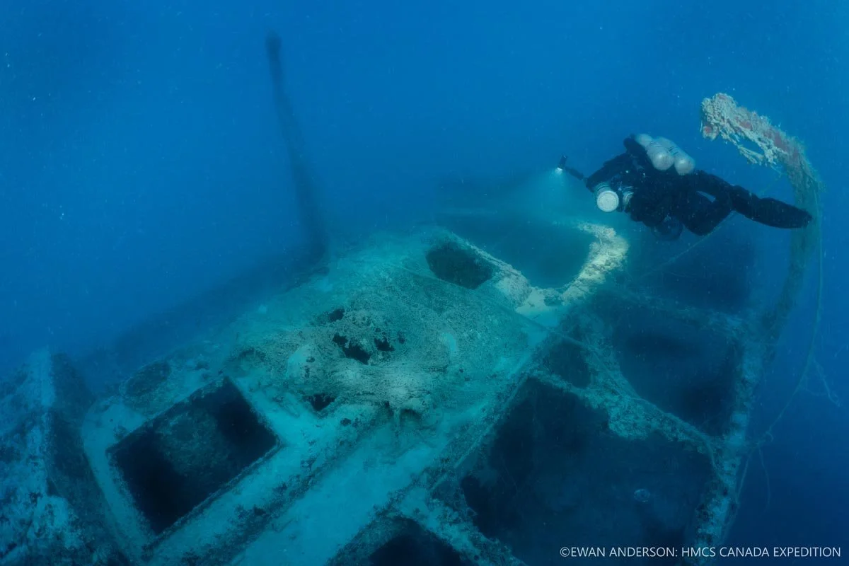 Diver Jason Cook illuminates a decaying fishing net draped across the engine-room skylights.