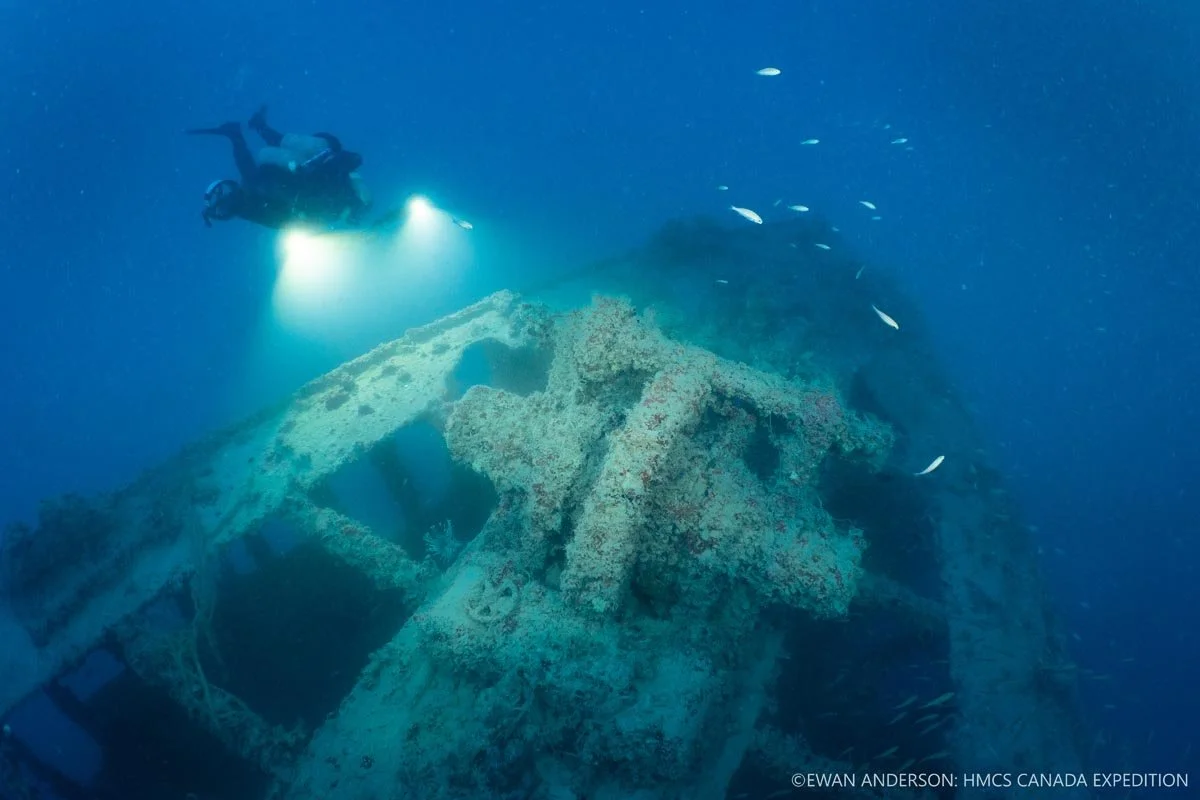 Diver Jason Cook illuminates the anchor windlass on the foredeck of HMCS Canada.