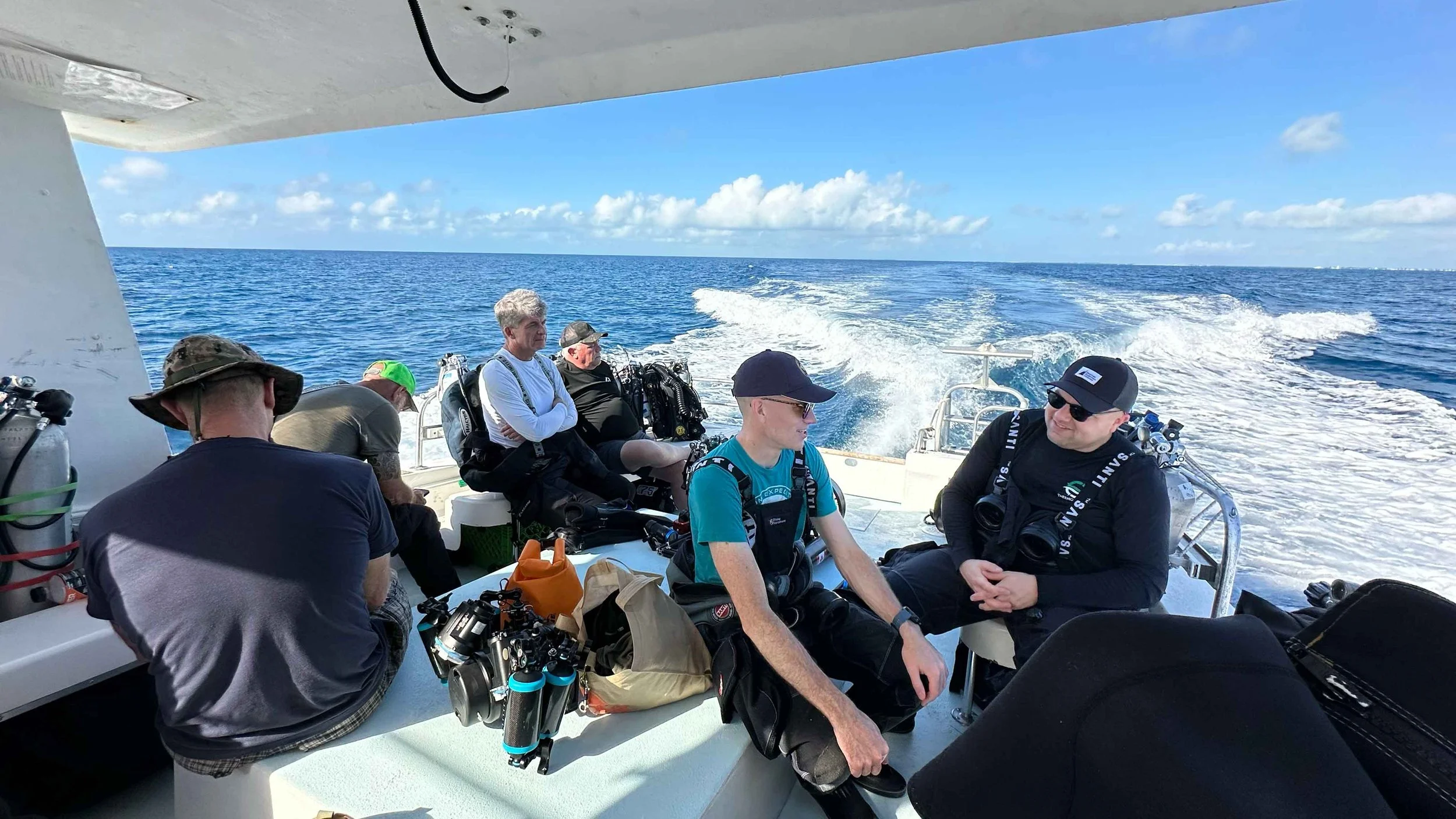 The expedition’s three two-person dive teams assembled on deck. Team 1 (left, stern): Roger Lacasse and Guy Shockey. Team 2 (centre, left to right): Ewan Anderson and Jason Cook. Team 3 (left, forward, backs turned): Rob DeProy and Kelvin Davidson.