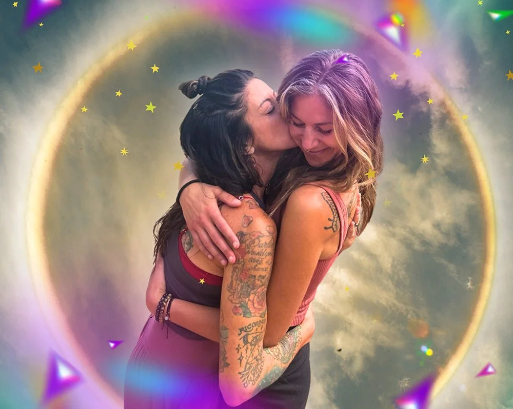 Mel & Elisa are the women behind Joytown seen here hugging and smiling, standing in front of a colorful, cosmic background to represent transformational healing through love & embodiment.