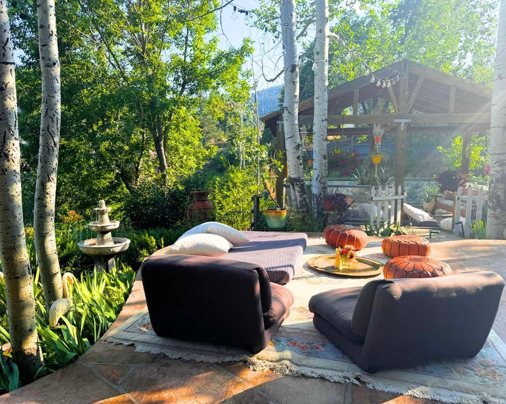 A cozy outdoor patio with a seating area f at Joytown, a transformational retreat & tantra sanctuary in Colorado.