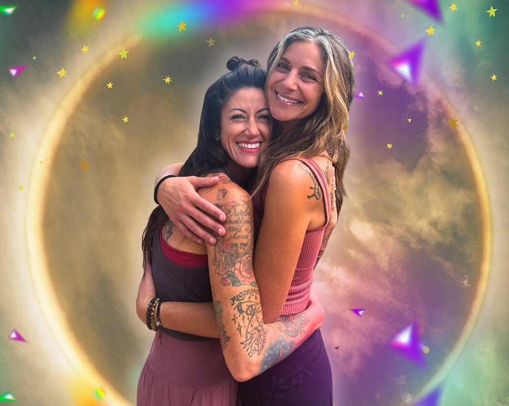 Mel & Elisa are the women behind Joytown seen here hugging and smiling, standing in front of a colorful, cosmic background to represent transformational healing through love & embodiment.