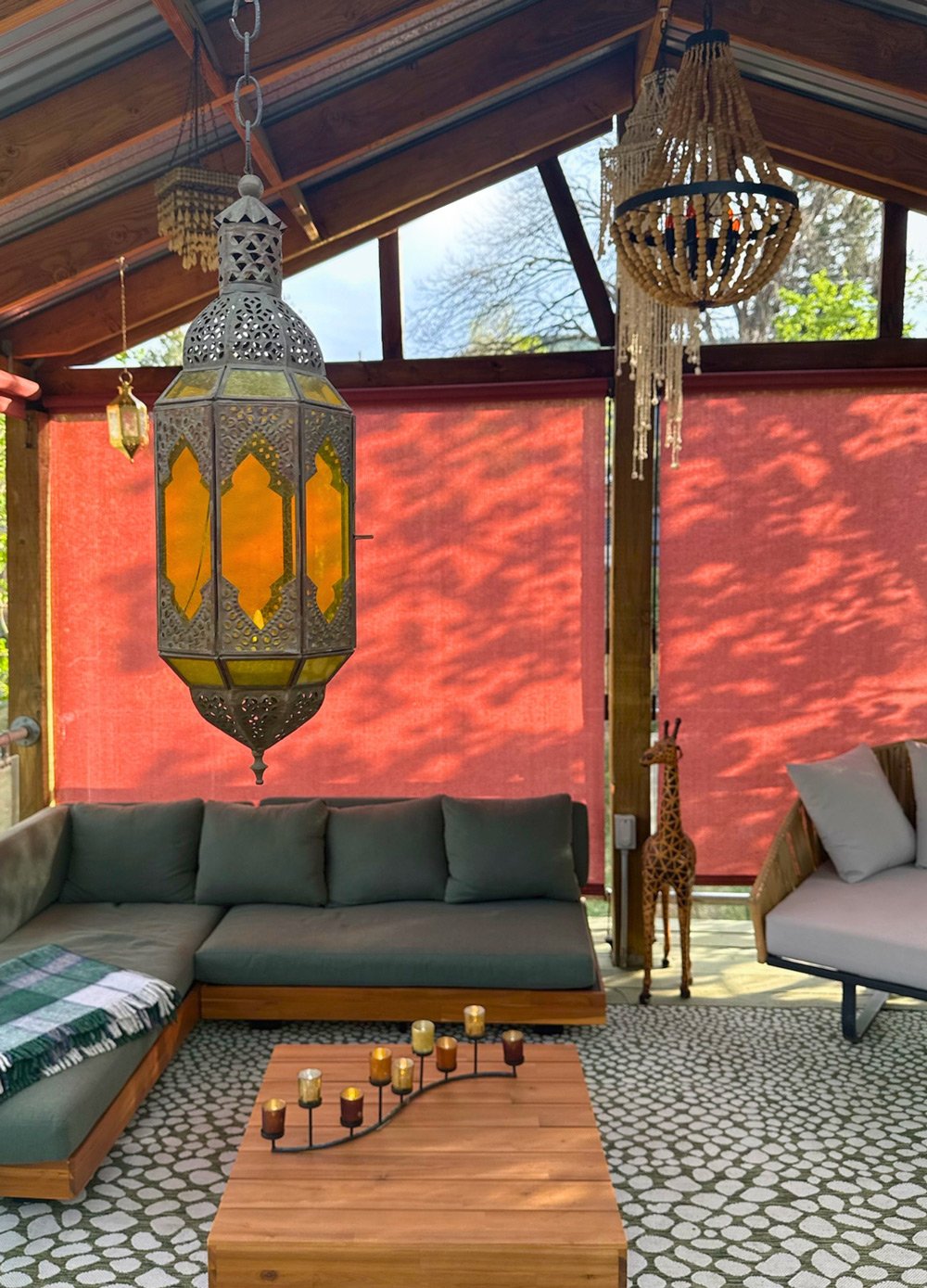 Indoor living space with Moroccan-style hanging lantern, beaded chandelier, and wooden giraffe sculpture at Joytown, a transformational retreat & tantra sanctuary in Colorado