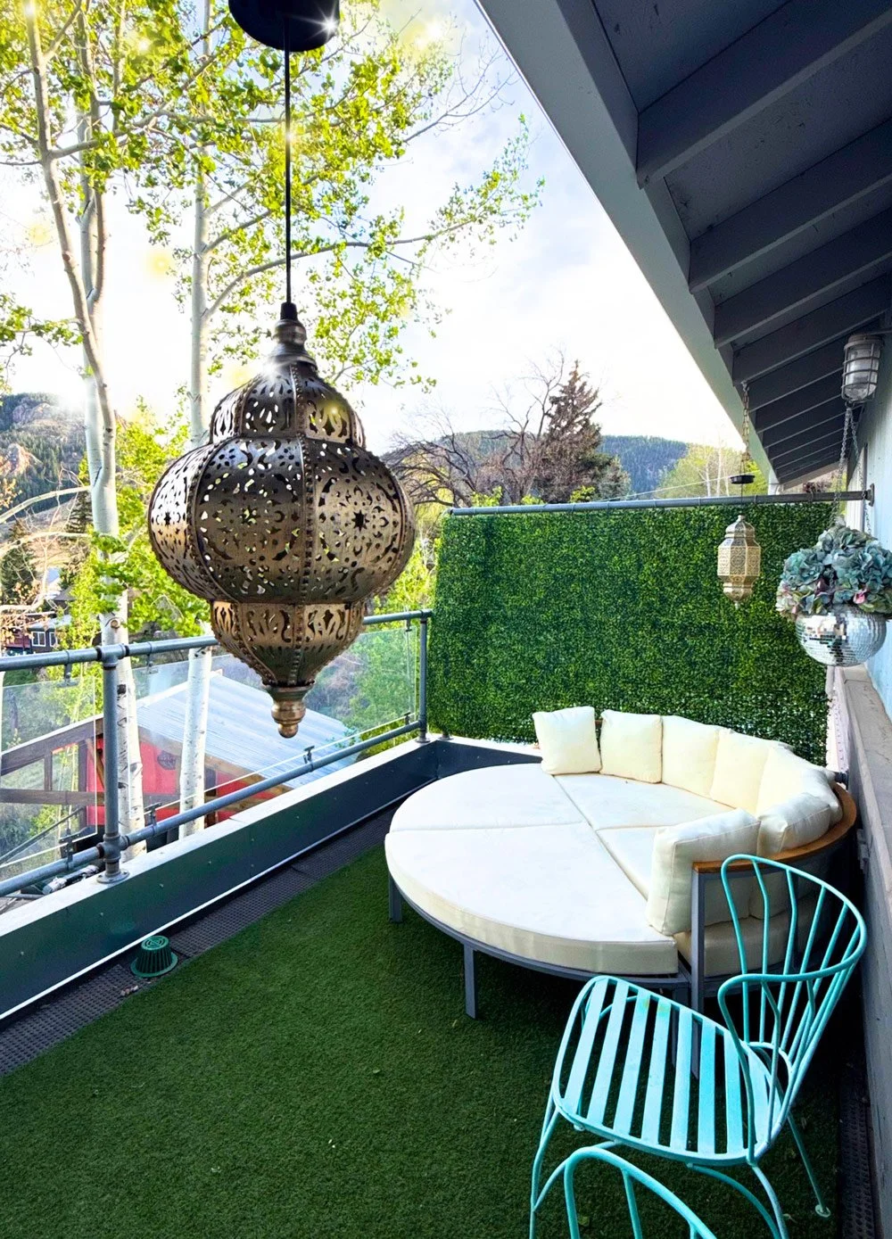 A balcony decorated with a hanging Moroccan-style lantern at Joytown, a transformational retreat & tantra sanctuary in Colorado.