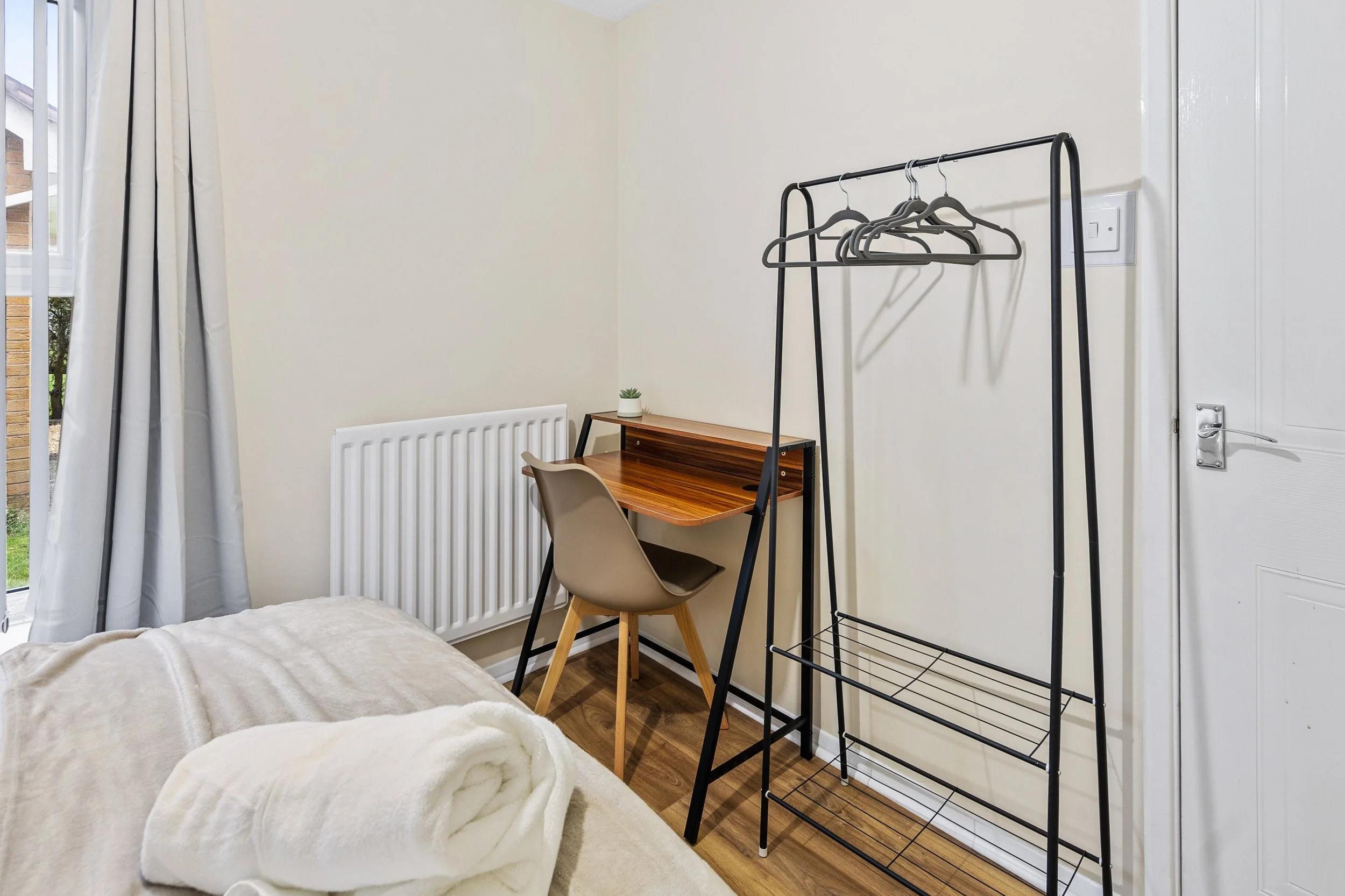 Work desk, chair and clothes rail in a twin bedroom at our Thorpe Astley accommodation in Leicester.