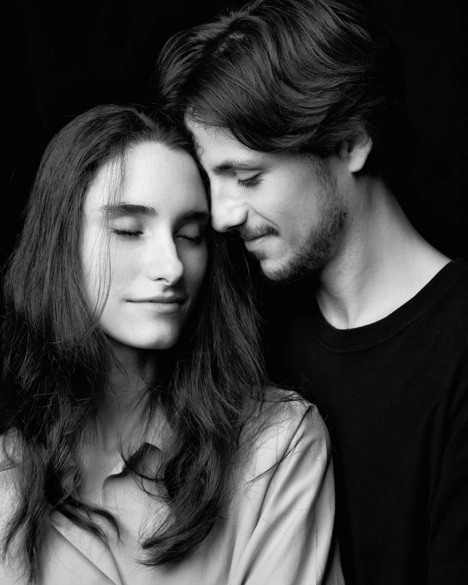 Una coppia di giovani innamorati che si abbracciano con occhi chiusi, in bianco e nero.