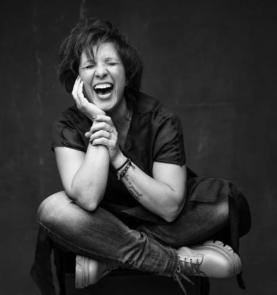 Donna seduta che ride con espressione felice