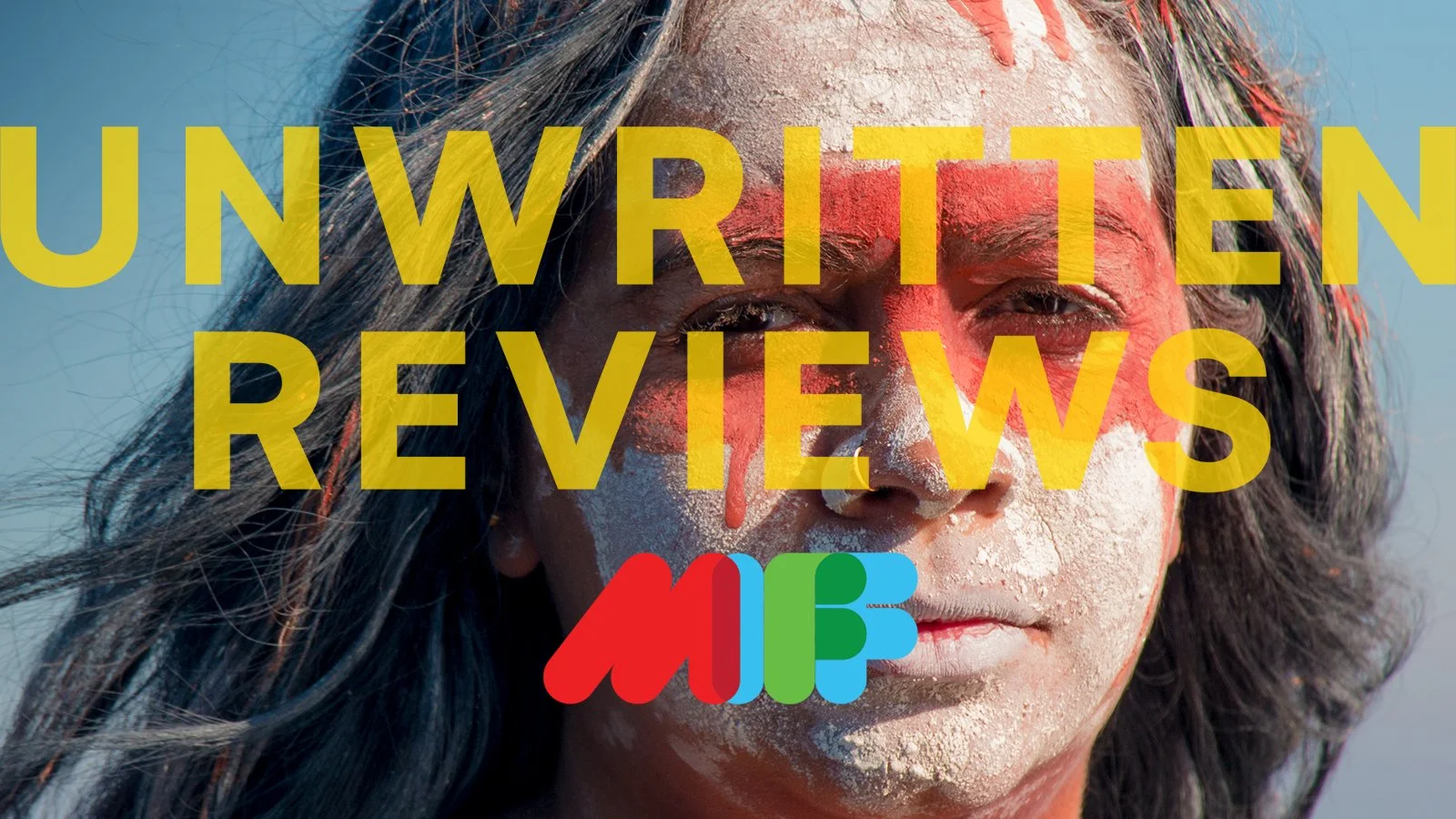 Pat Baron. A person with long dark hair and white face paint, blown by the wind, with large yellow text overlaying it that reads 'UNWRITTEN REVIEWS' and a colorful logo below.