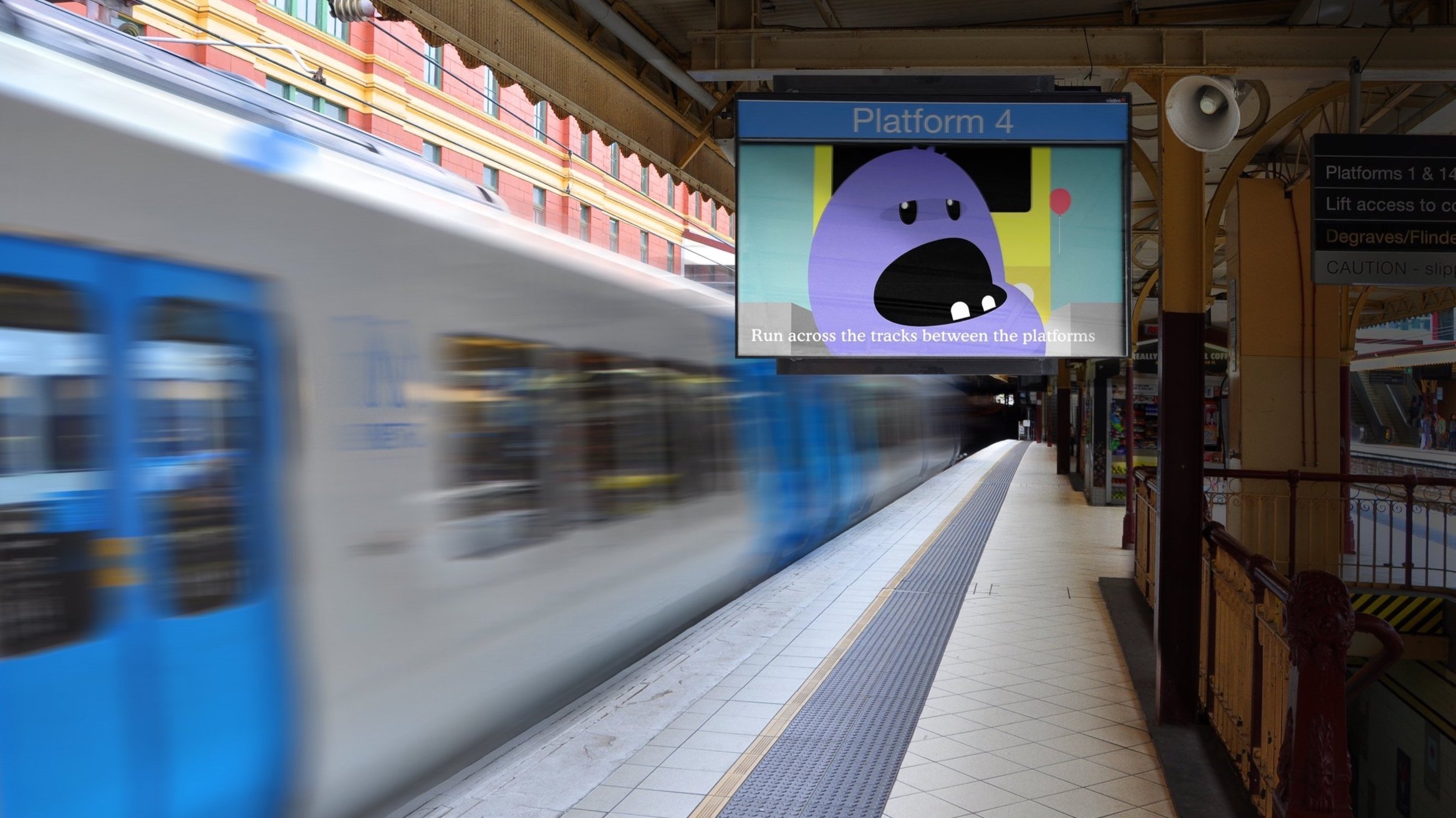 Blurred train at a station with a safety warning screen displaying a cartoon character on Platform 4.