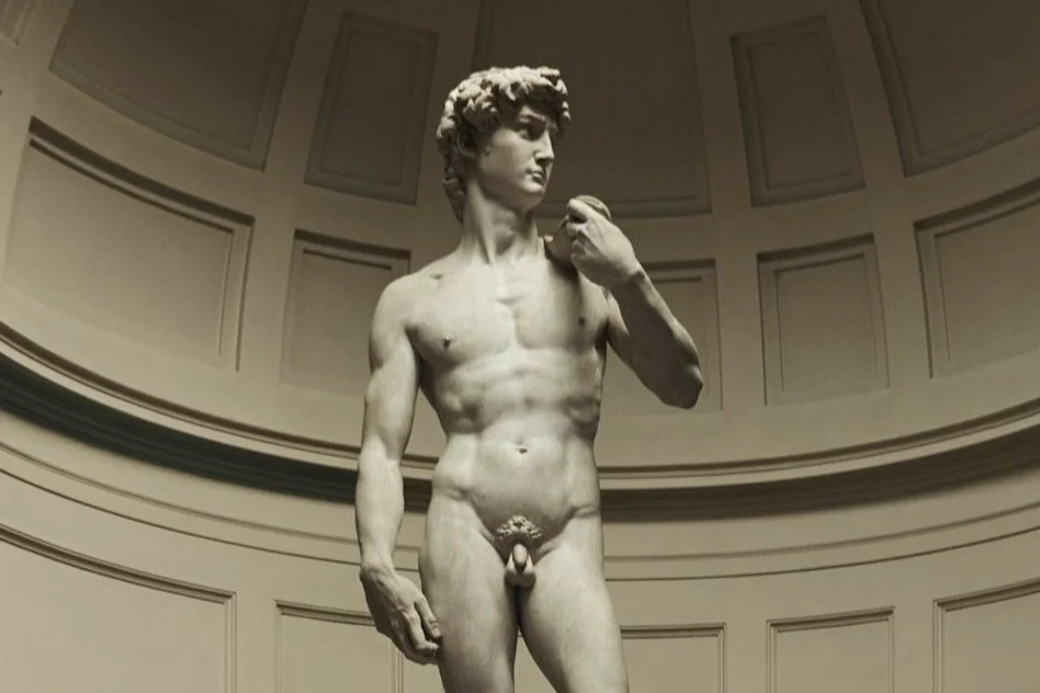 Statue of David by Michelangelo in a museum setting.