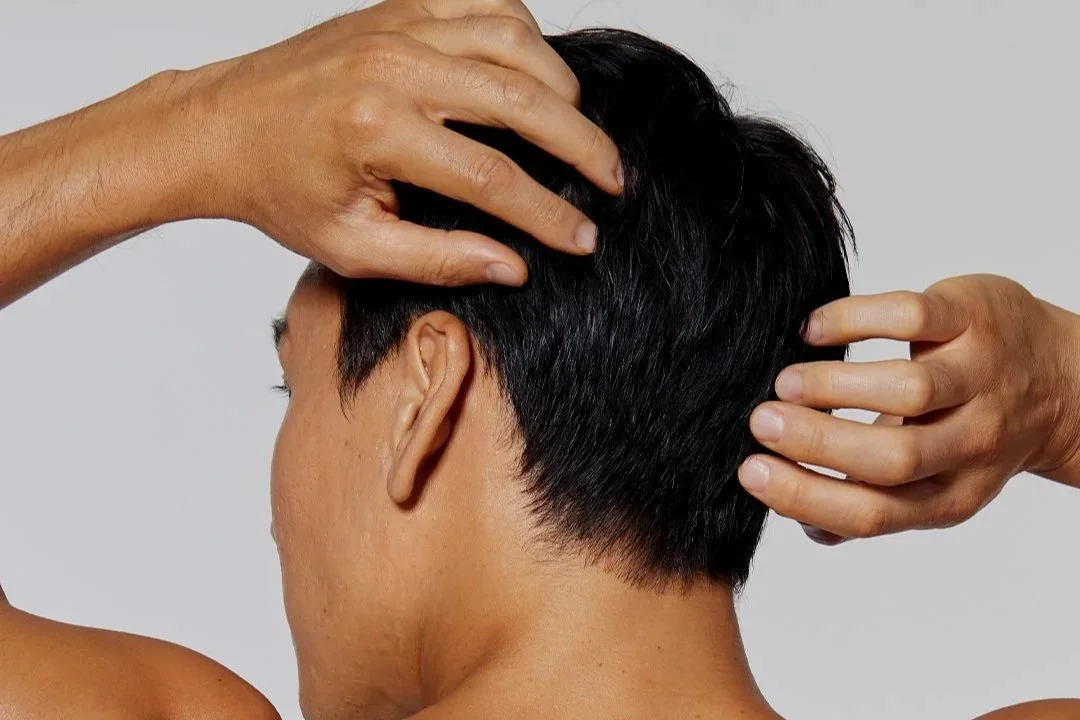 Man touching his scalp, representing the Hydrafacial Keravive scalp treatment at The Ivy Day Spa.