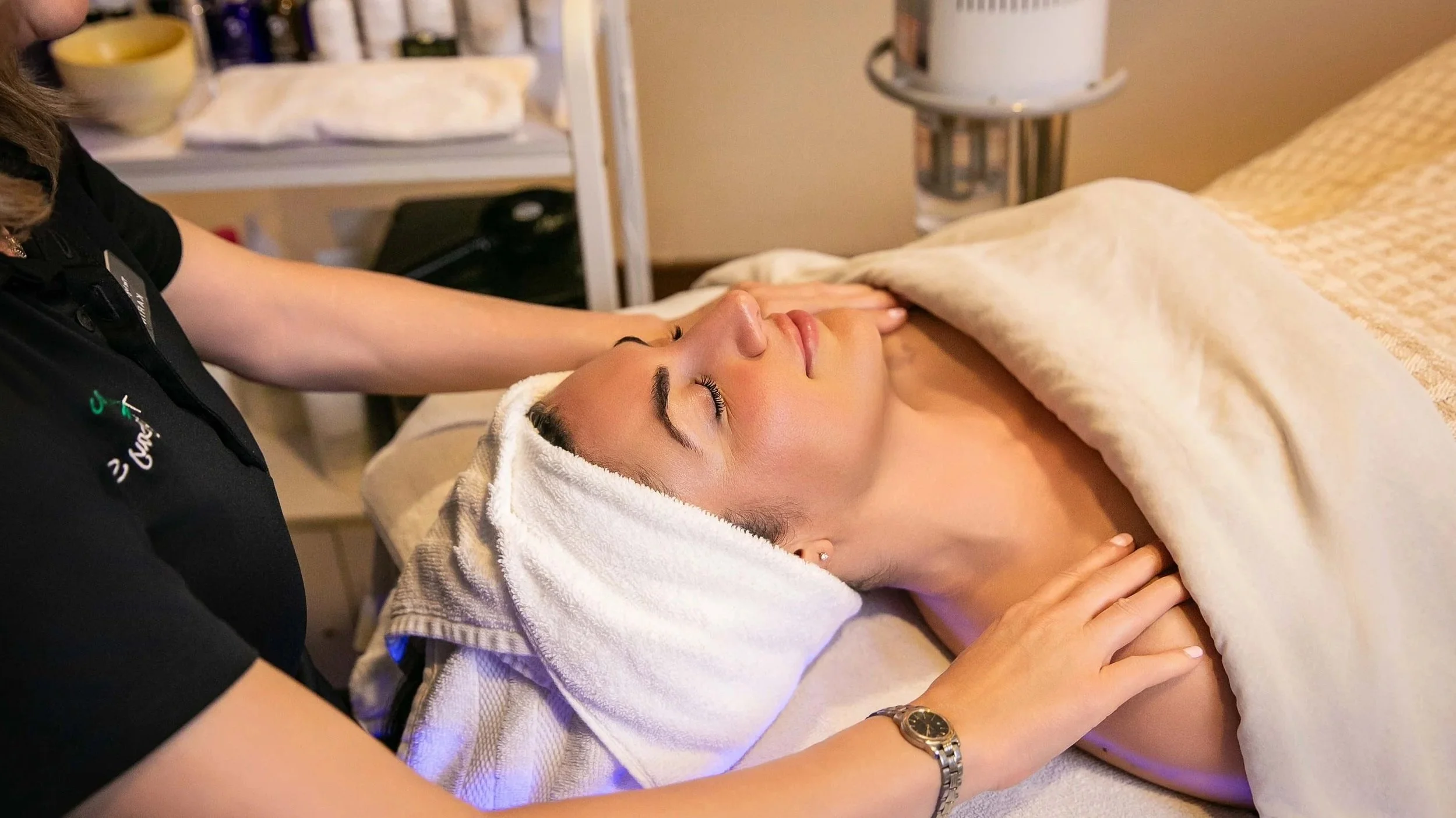 Guest receiving a relaxing facial treatment at The Ivy Day Spa, highlighting client review praising massages, facials, and attentive staff.