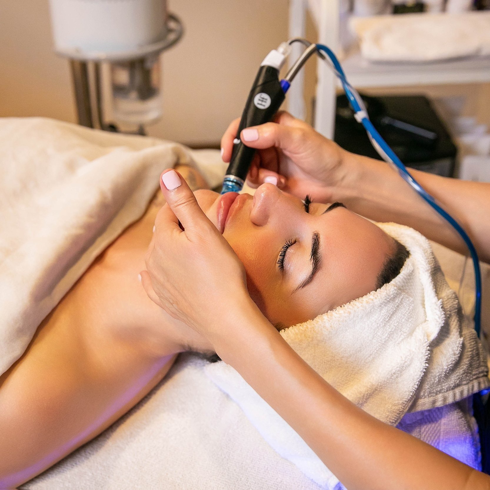 Woman receiving a HydraFacial treatment at The Ivy Day Spa in Santa Clarita, using the Vortex Fusion system for radiant skin.