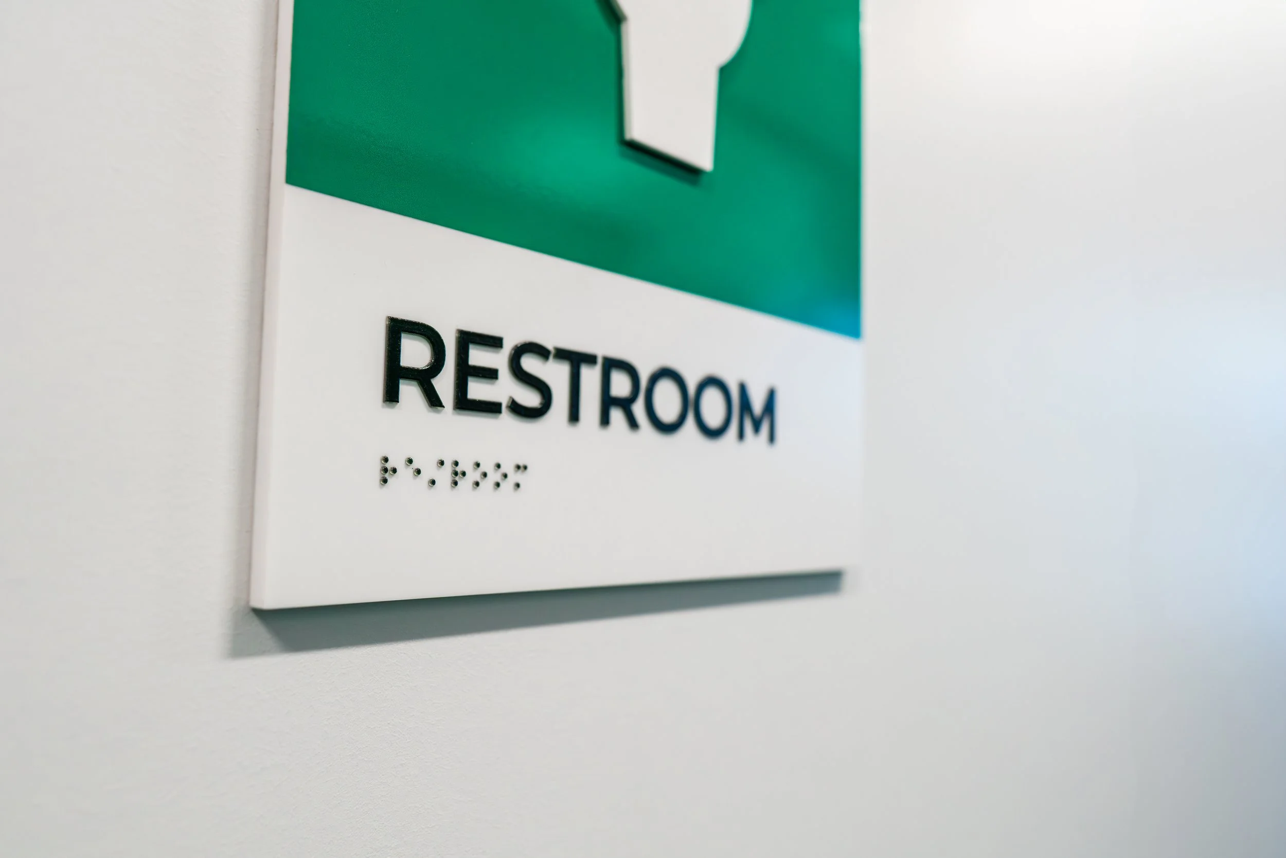 YNCU dimensional acrylic restroom sign with tactile letters and braille