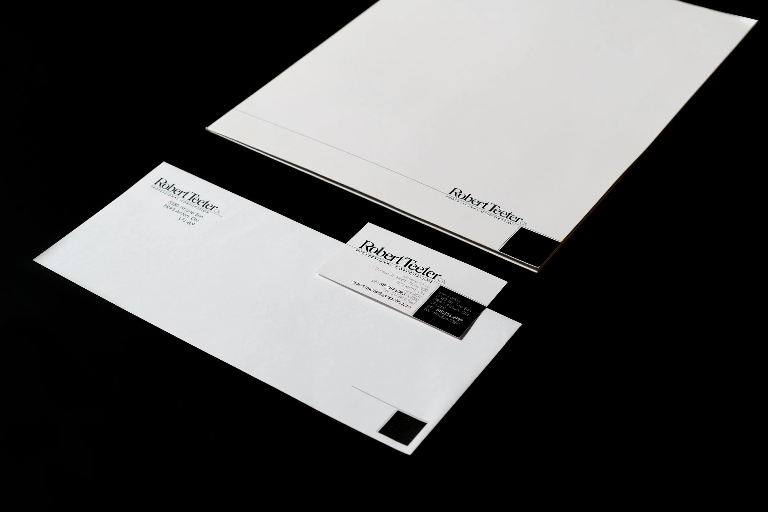 Set of branded professional stationery including letterhead, business card, and envelope with the name Robert Teeter, on a black background.