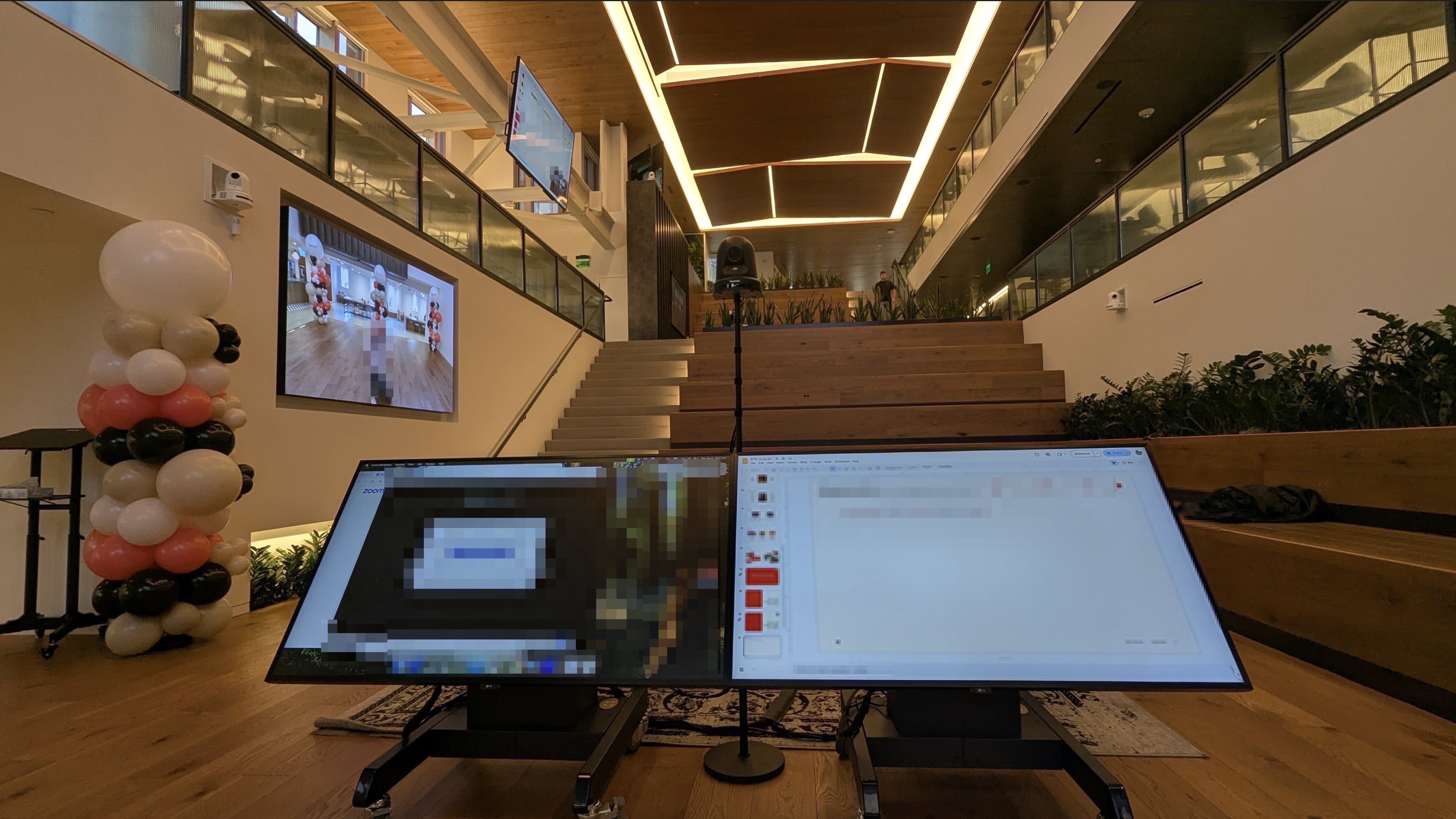 Interior of a modern office with large screens displaying a video call.