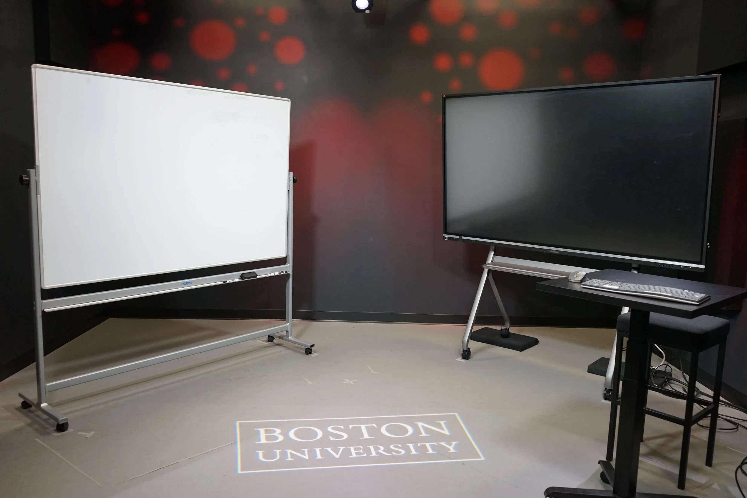 Interior of a modern office with large screens displaying a video call.