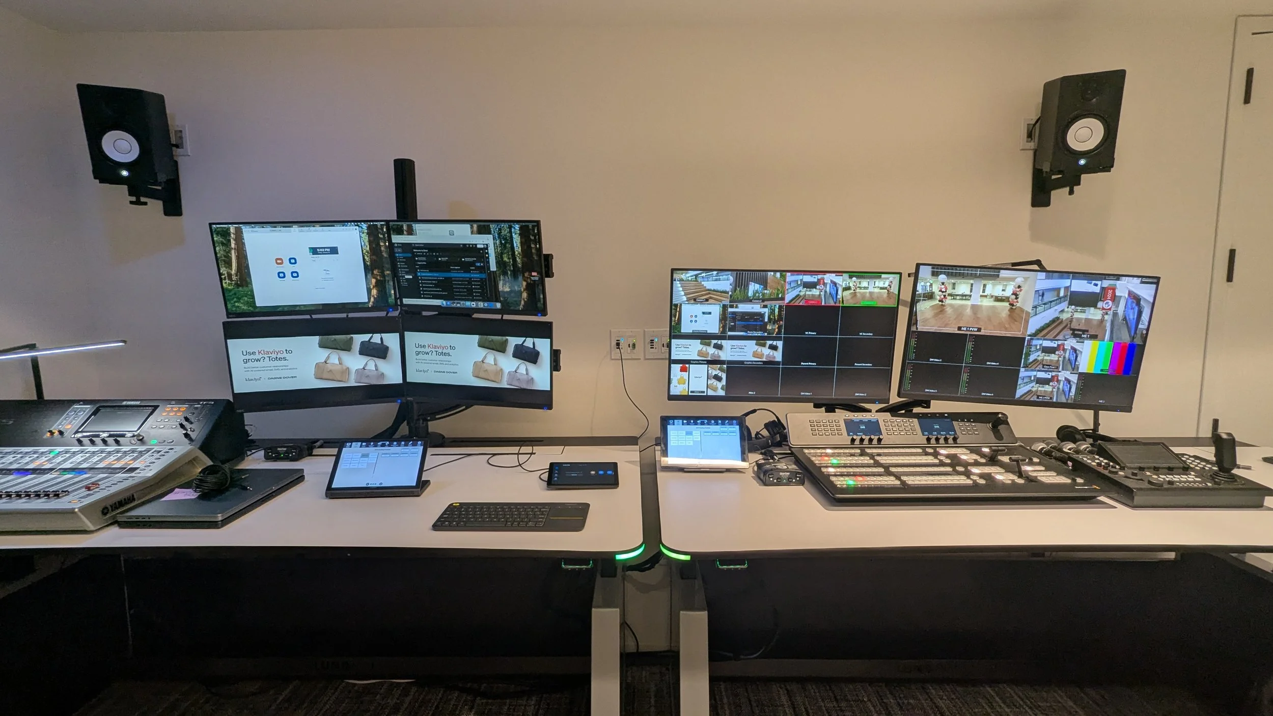 Modern video and audio production control room with multiple monitors, mixer, keyboards, speakers, and broadcast equipment.