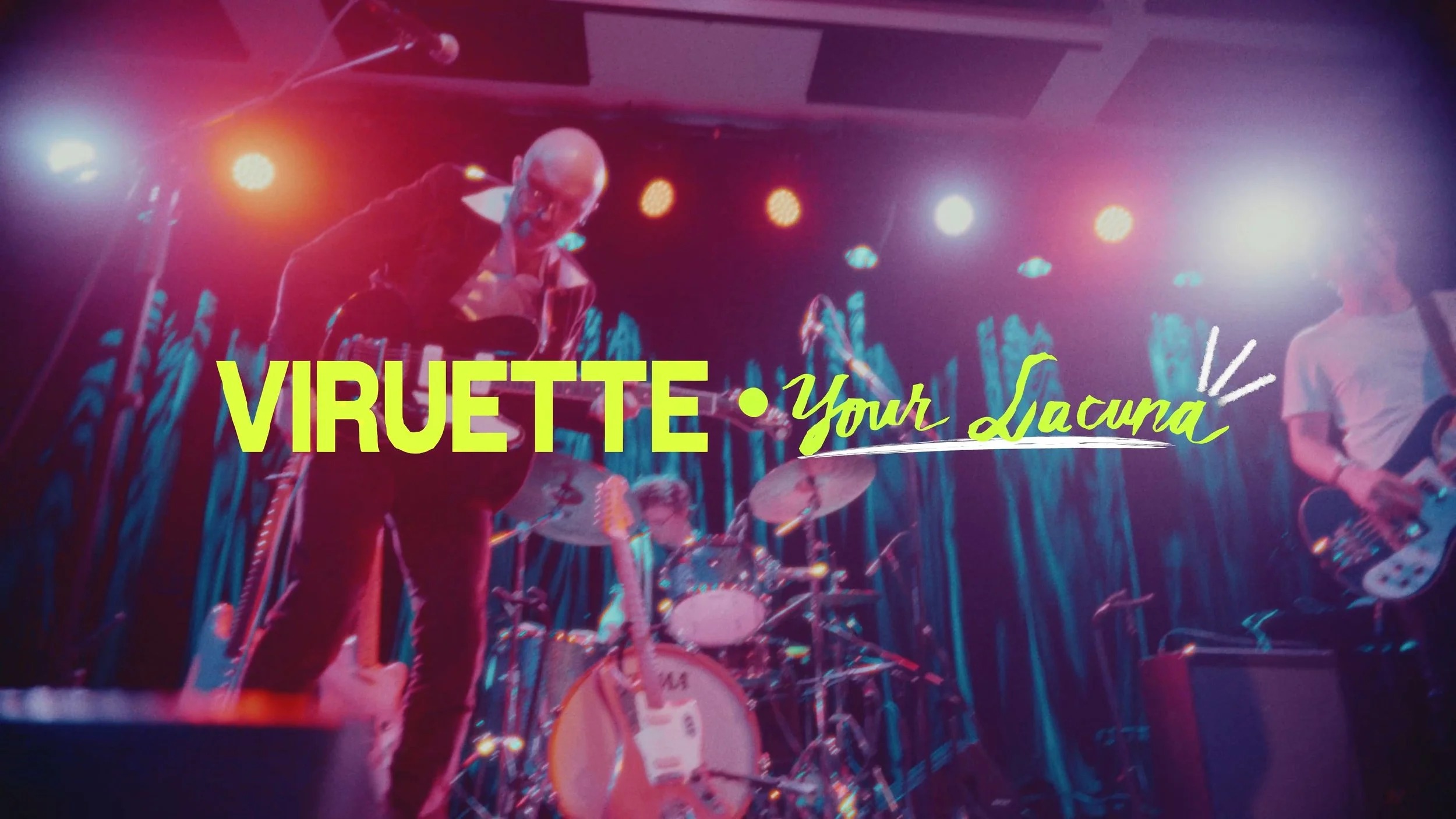 Colorful concert scene with musicians on stage, bright lights, and a sign that reads 'Viruette Your Launa' in yellow and green lettering.