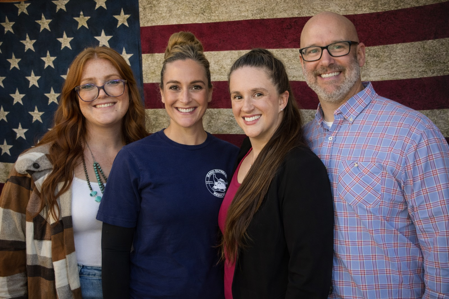 Idaho Outreach team members standing in front of an American flag, smiling and approachable.