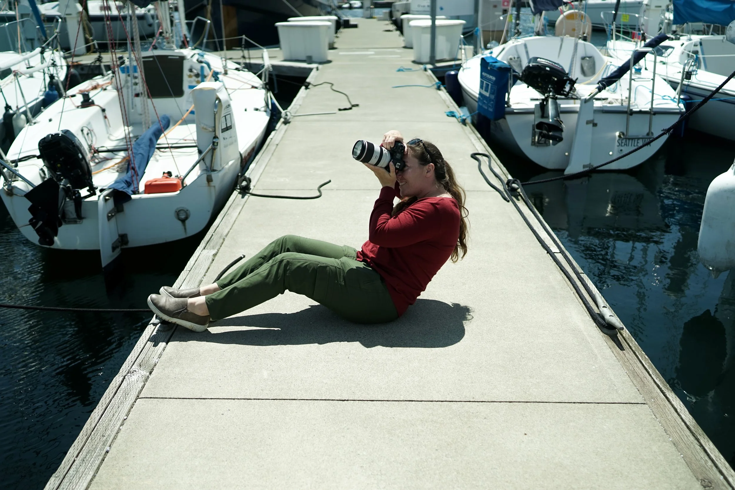 social media marketer photographing while sitting on a dock in a marina
