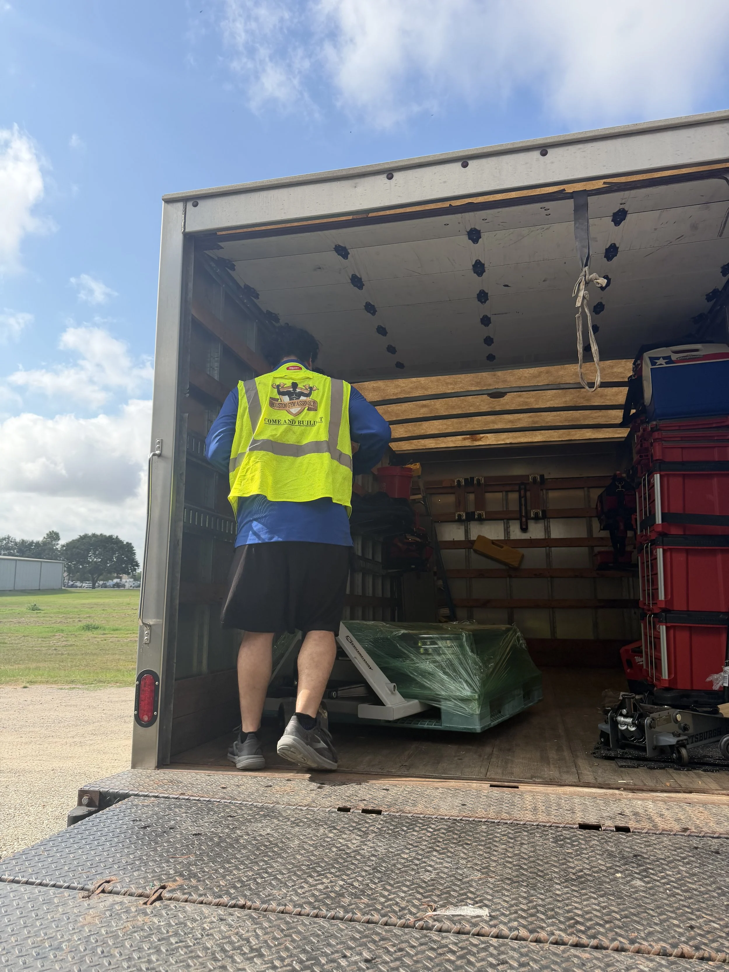 Houston Gym Assembly technician loading gym equipment into a box truck for a fitness equipment relocation in Houston, TX