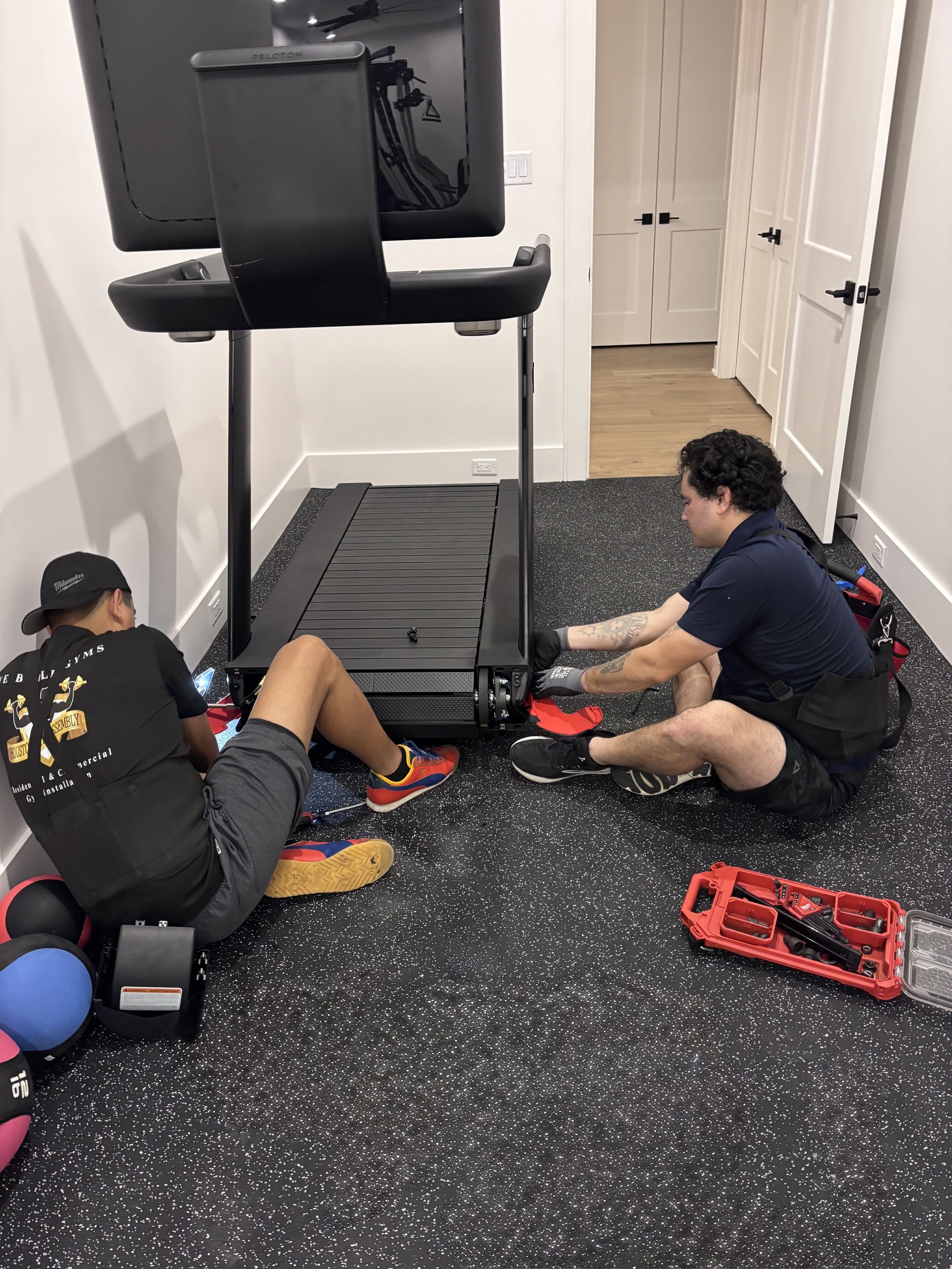 Houston Gym Assembly technicians reassembling a Peloton Tread Plus after a second-floor relocation