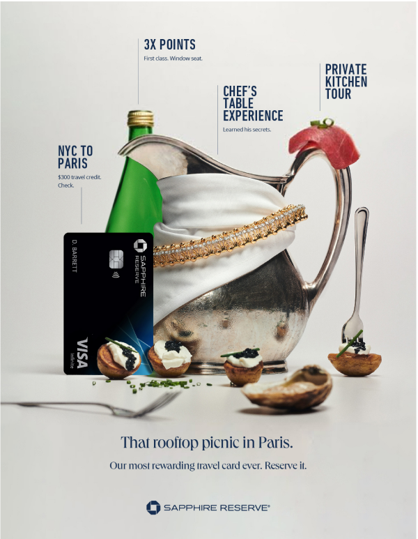 A promotional image for Sapphire Reserve travel card featuring a silver teapot with various items inside including a green bottle, a white cloth, and jewelry. In front of the teapot are small appetizers topped with black caviar and garnished with gre