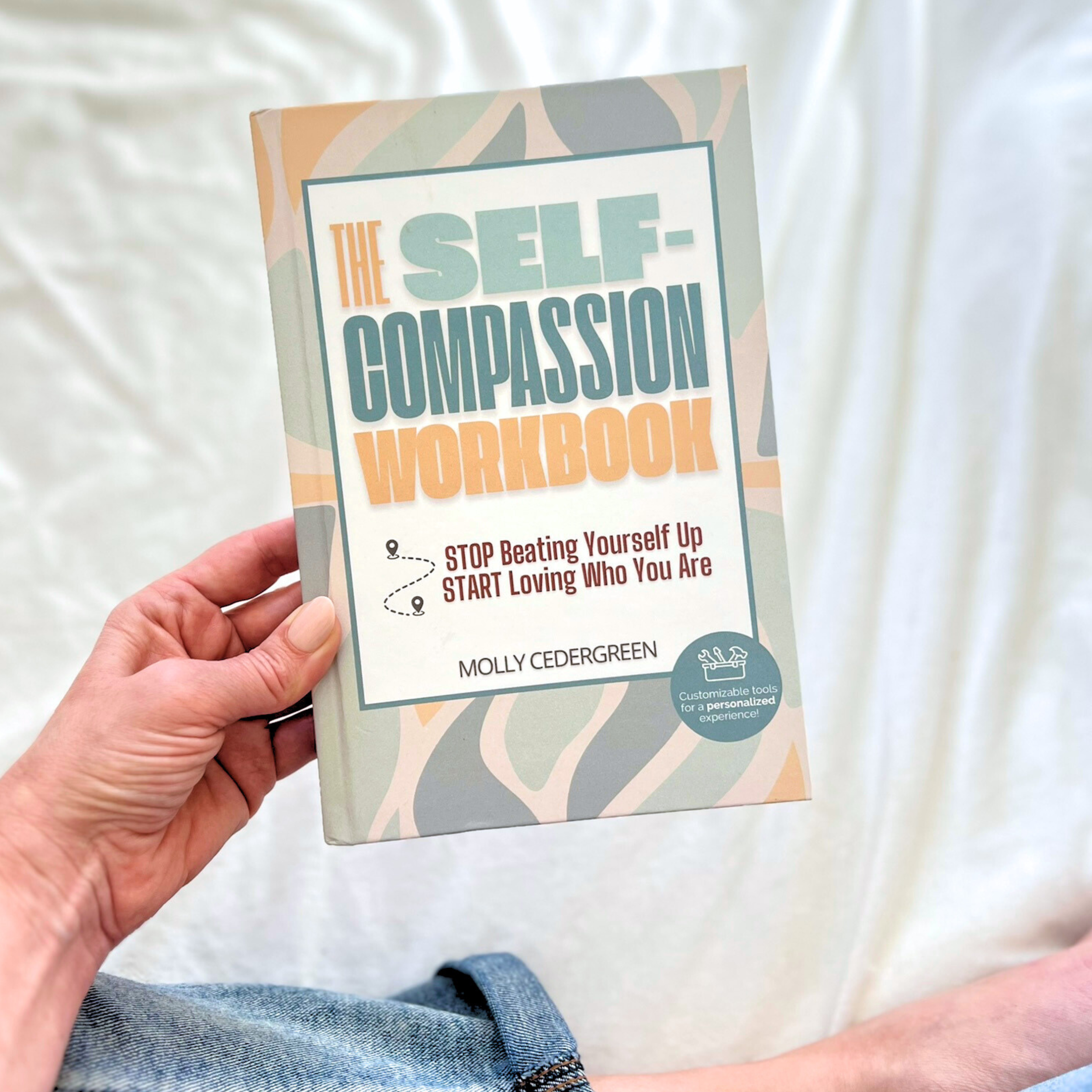 hand holding the self-compassion workbook.png