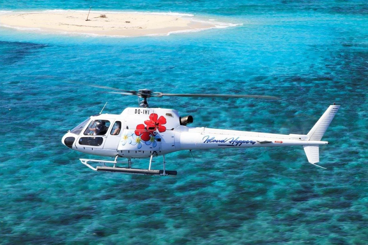 Helicopter flying over turquoise waters en route to the Yasawa Islands
