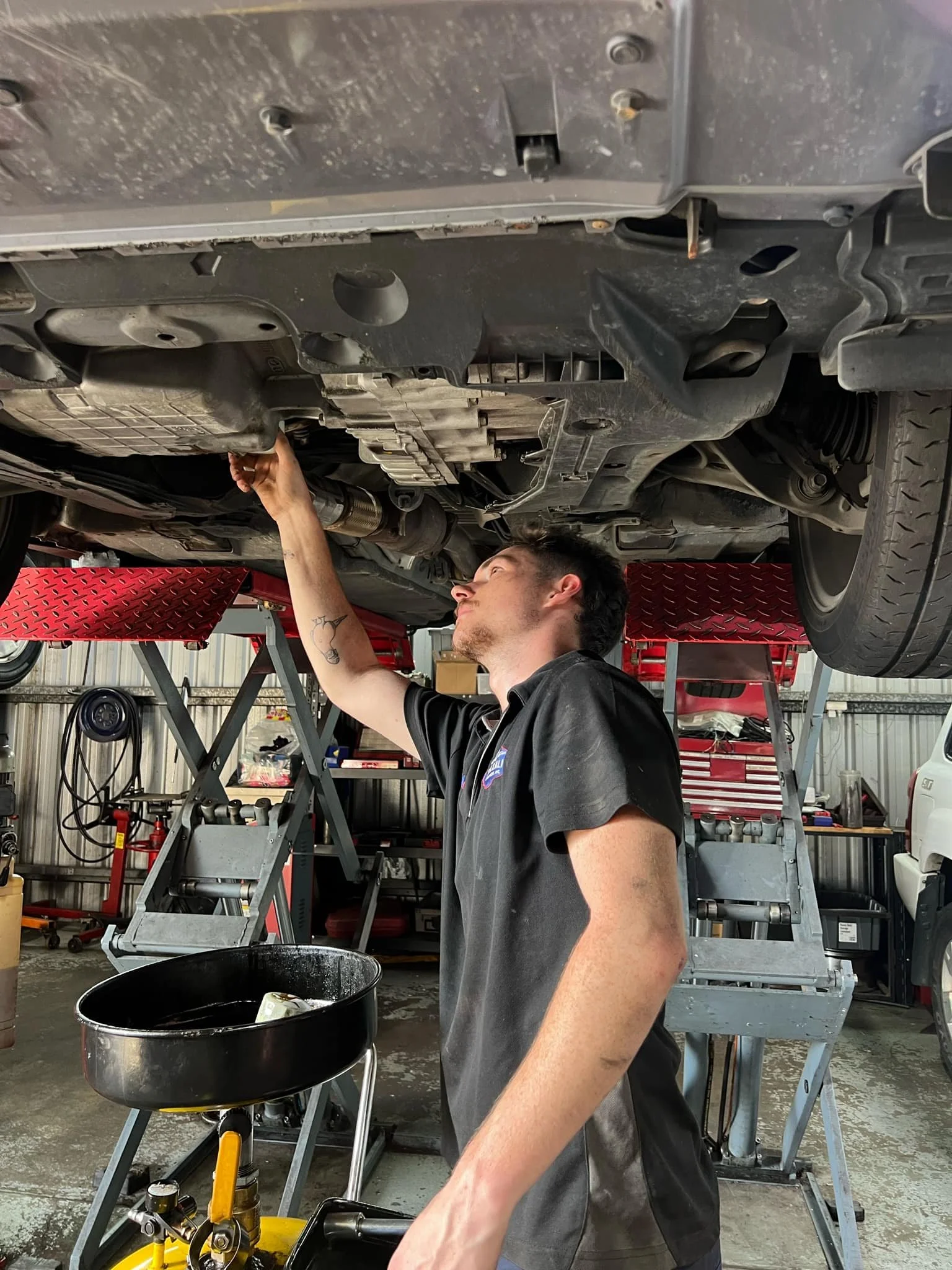 Mechanic inspecting under a car on a lift in a garage