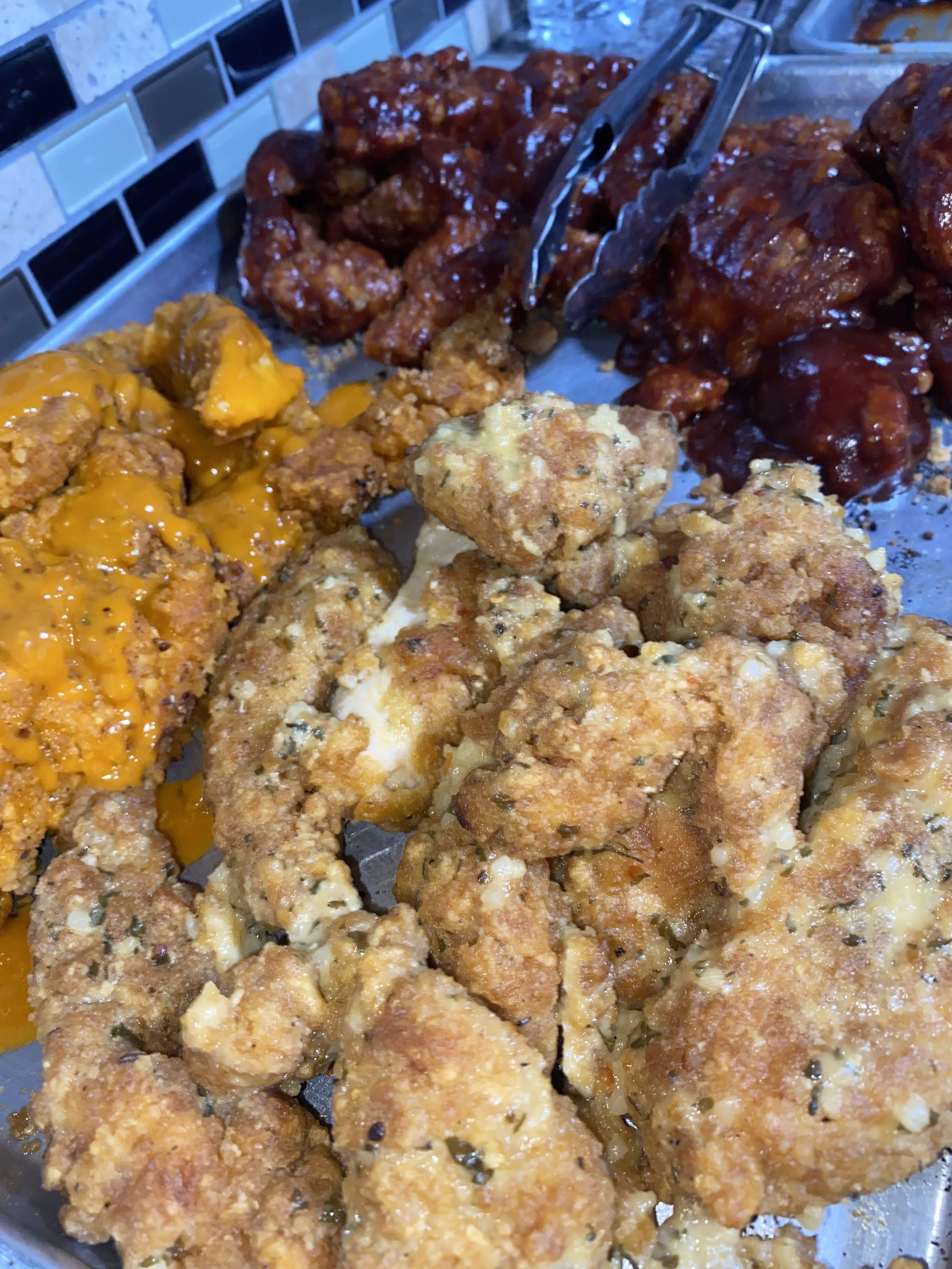 Close-up of assorted fried chicken pieces with different sauces, including cheesy, spicy, and plain fried chicken.