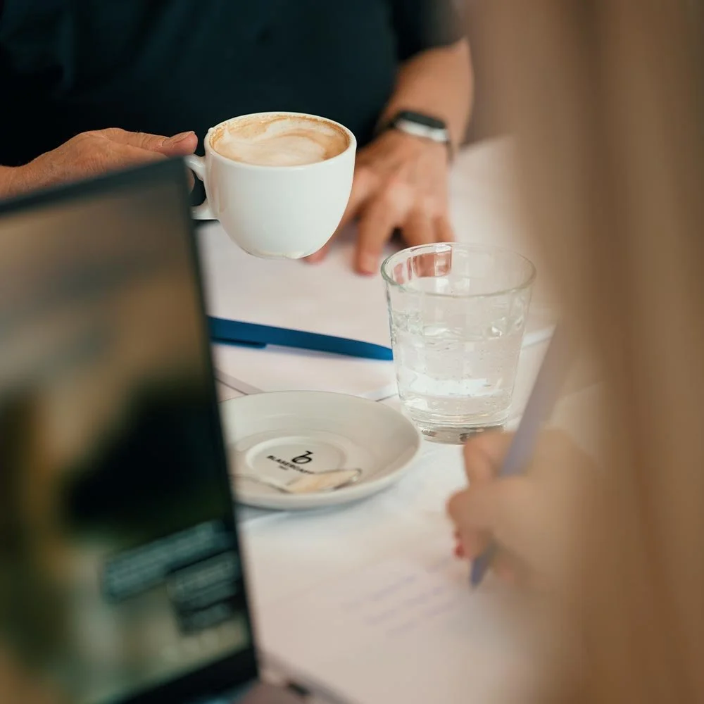 Kaffee und Notizblock im Seminarraum