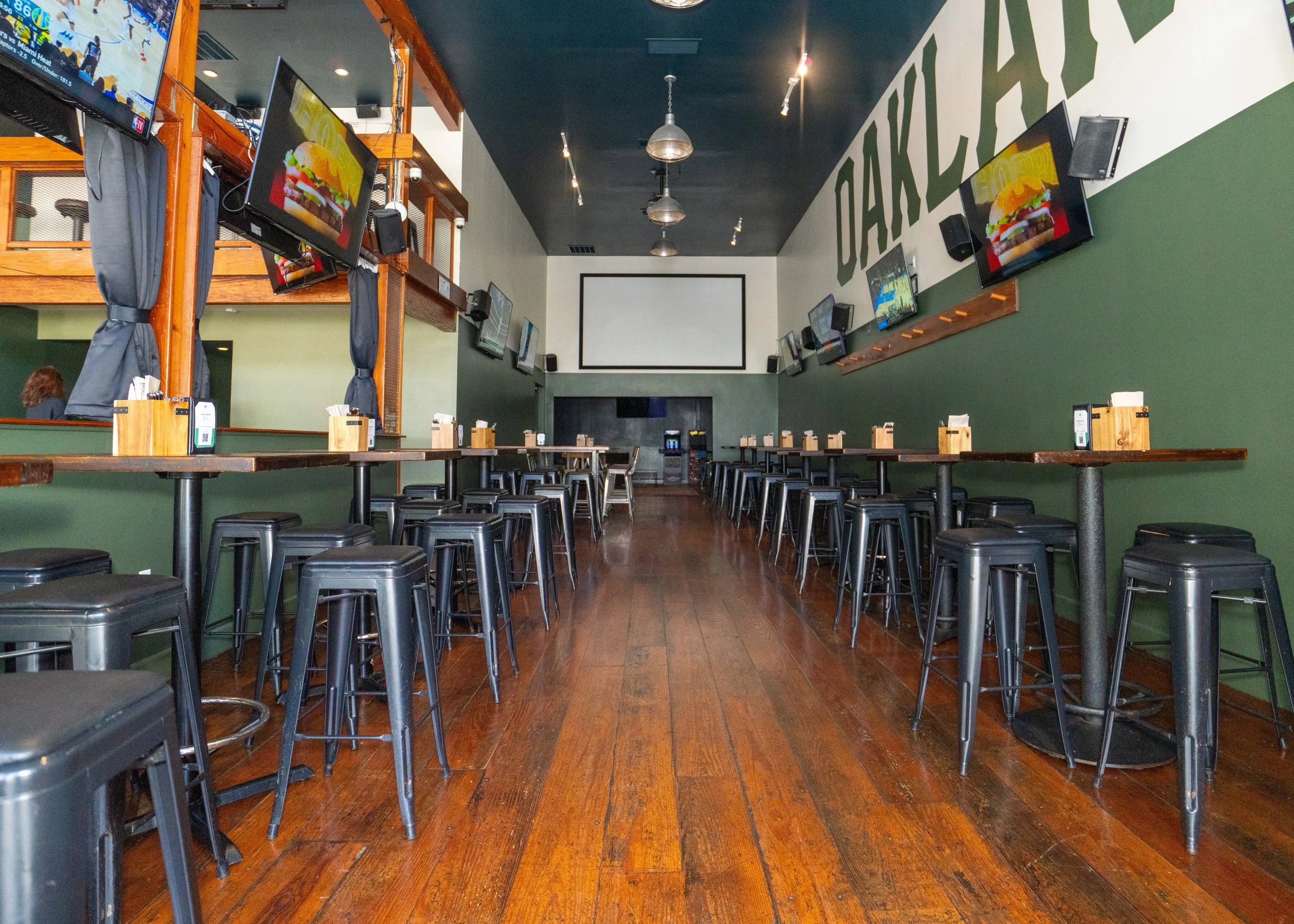 interior of bar, wood floor, tables, tvs