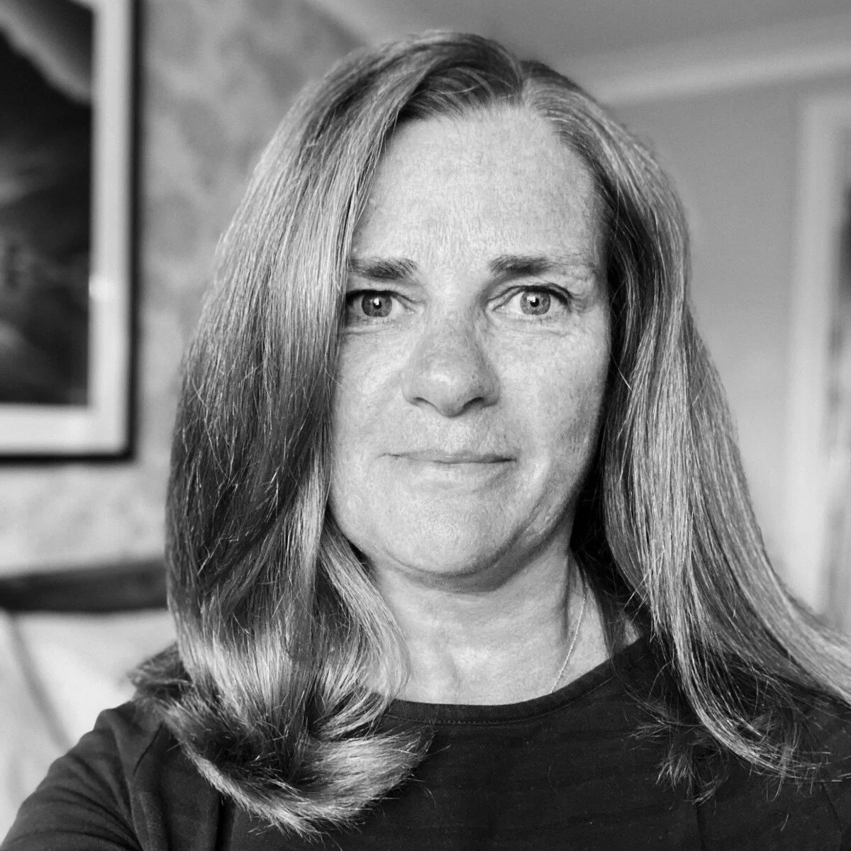 Black and white photo of a woman with long hair, looking directly at the camera.