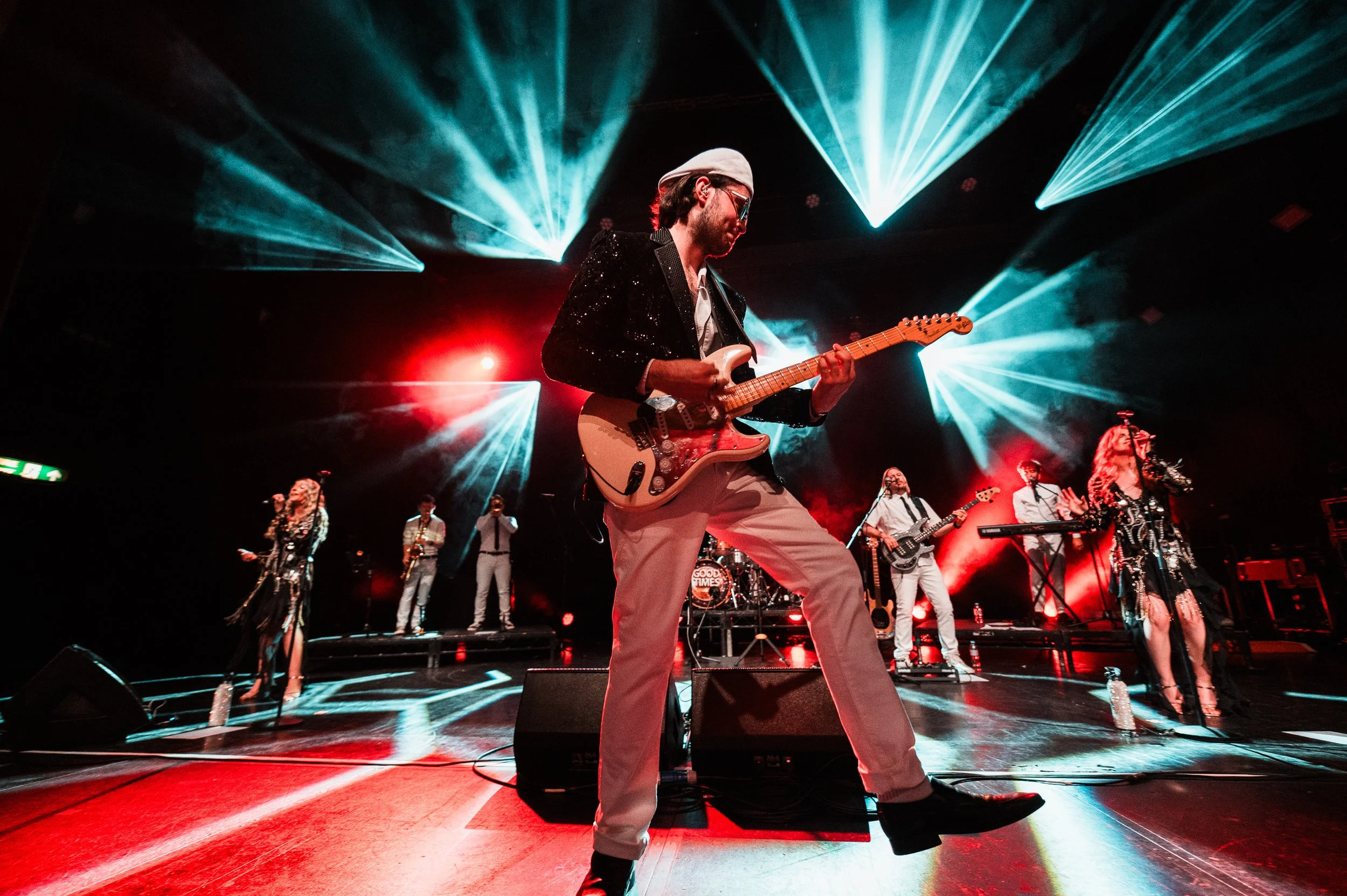 Good Times lead guitarist performing during a live theatre or festival show.
