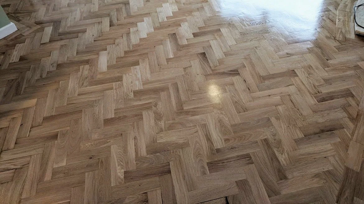 Wooden floor with a herringbone pattern.