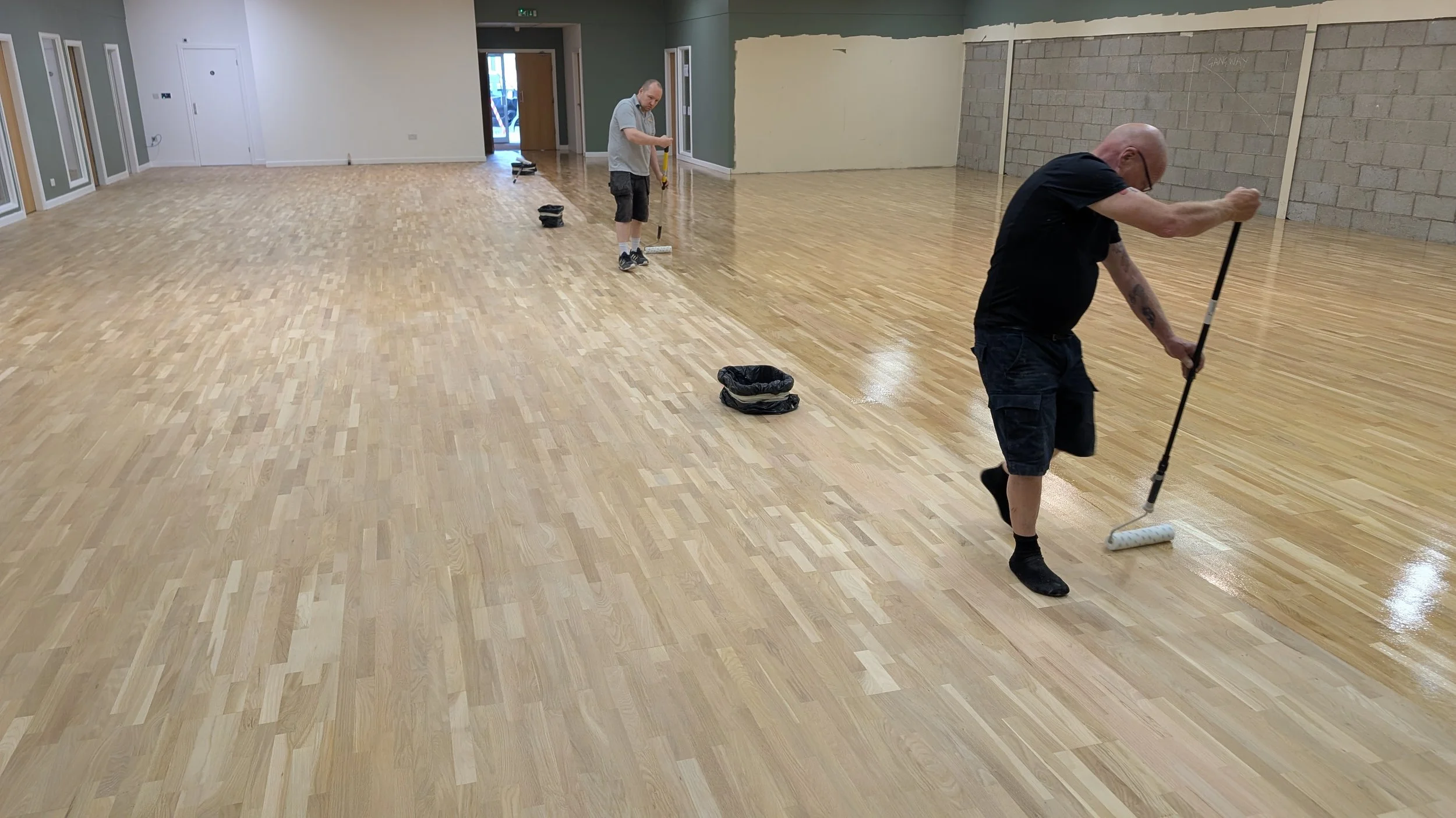 Commercial wood floor sanding and refinishing during varnishing