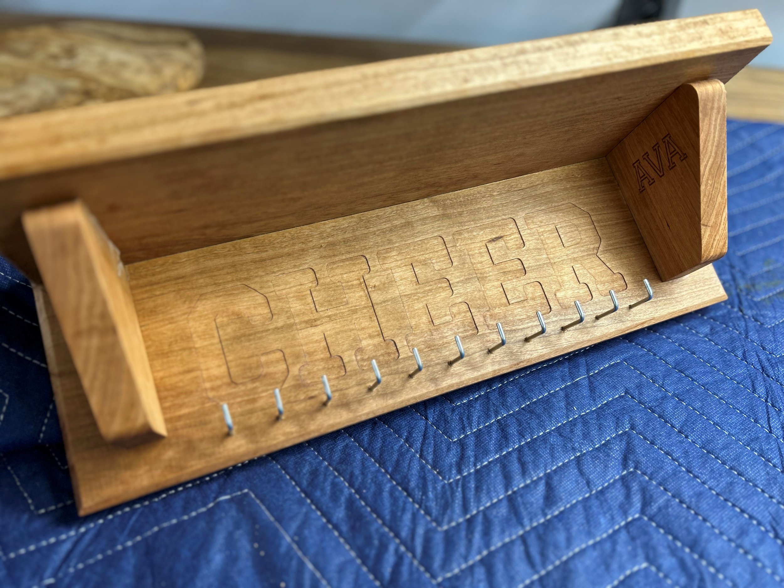 Cheerleading awards shelf with hooks for hanging medals made from cherry