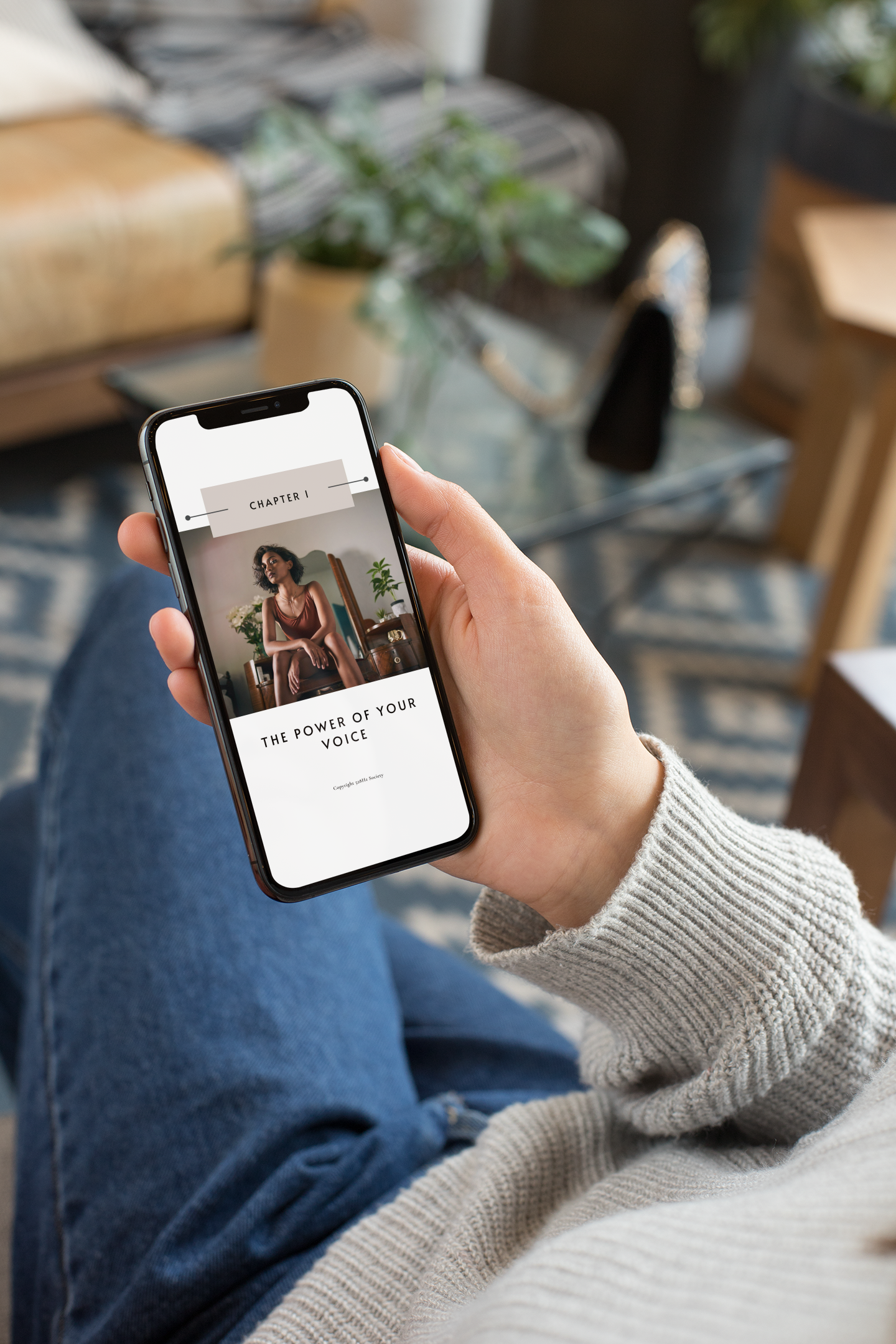 mockup-featuring-an-iphone-xs-being-held-by-a-woman-sitting-down-25356.png