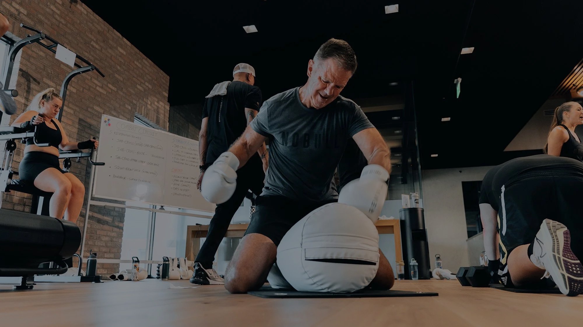 Man hitting a punching bag on the ground.