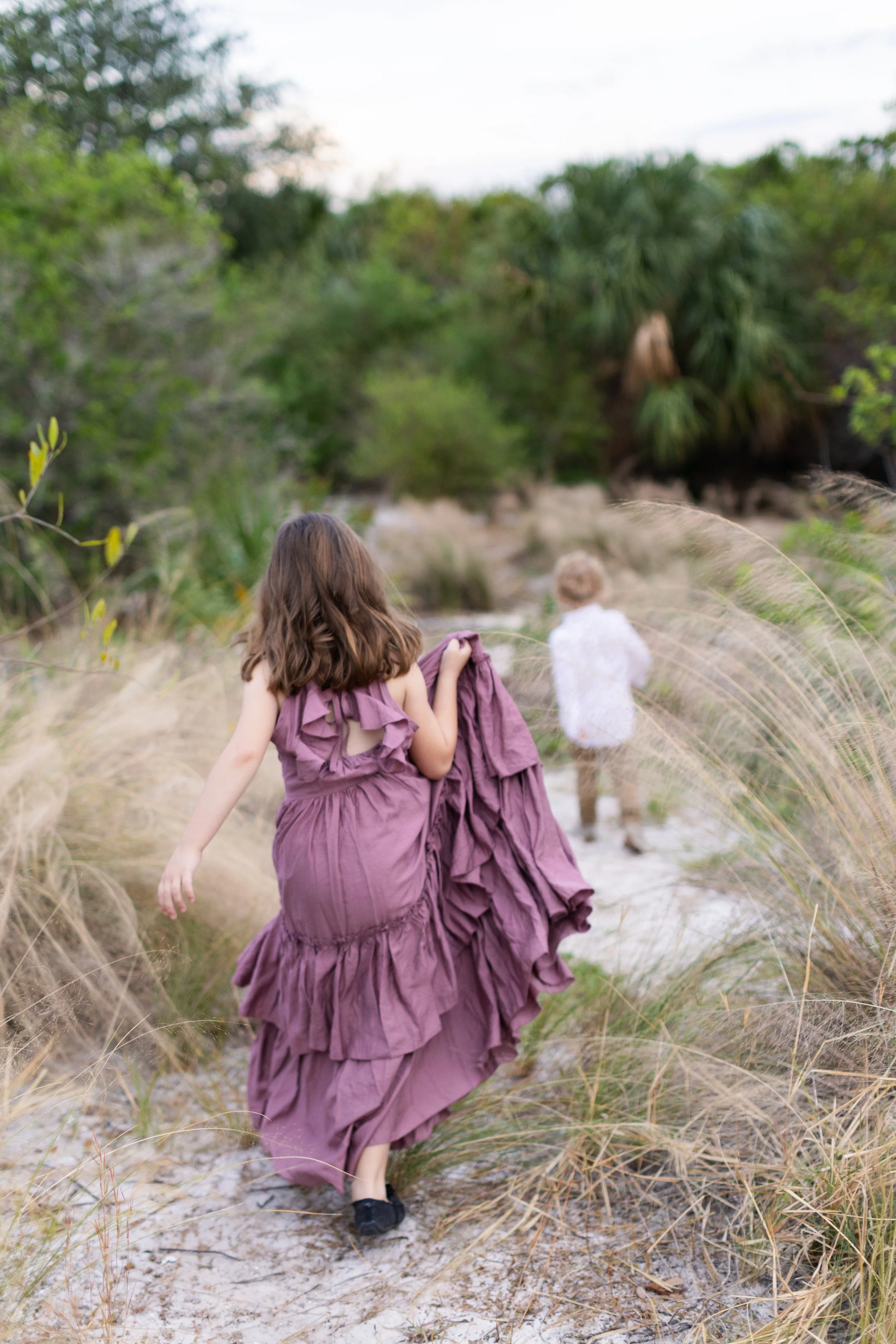 Children running through dune grass in Tampa, Florida, reflecting individualized behavioral and developmental support at Danielle’s Bright Beginnings