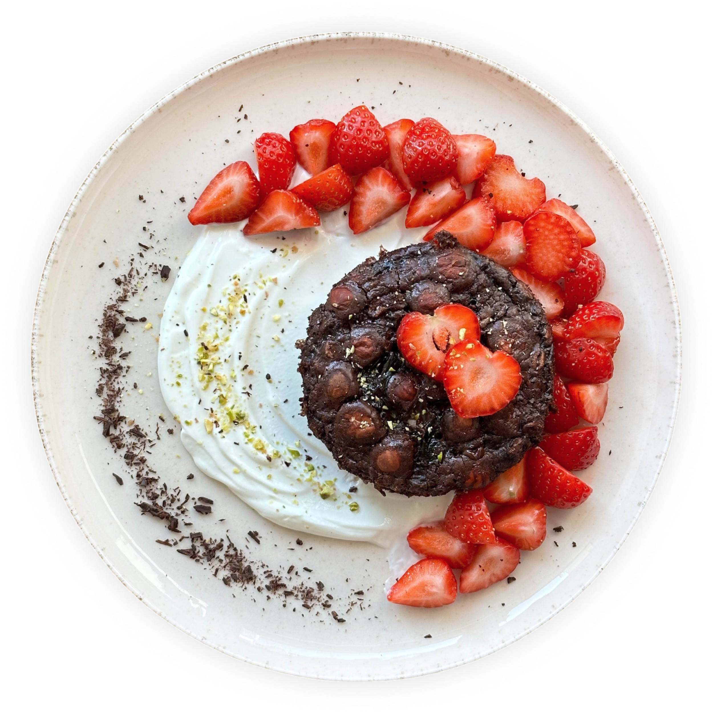 A dessert dish with sliced strawberries, dollops of whipped cream, sprinkled chocolate shavings, and a chocolate brownie on a white plate.