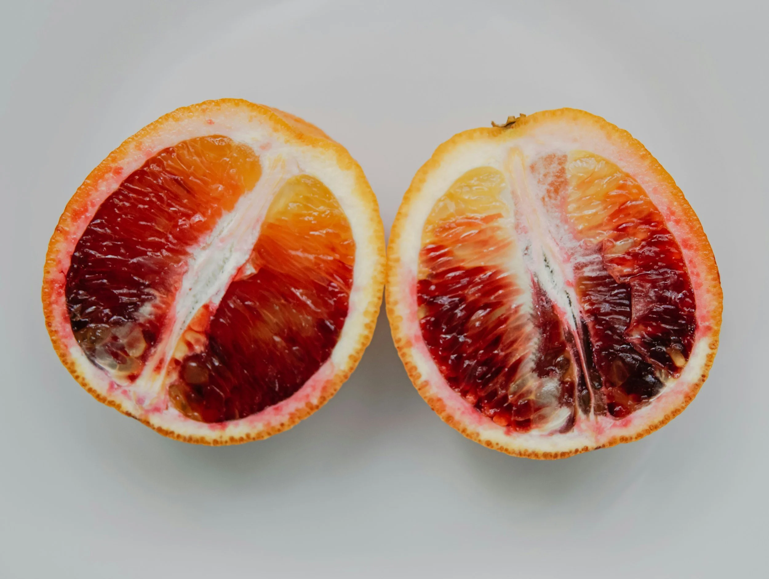 Half of a blood orange fruit on a white background.