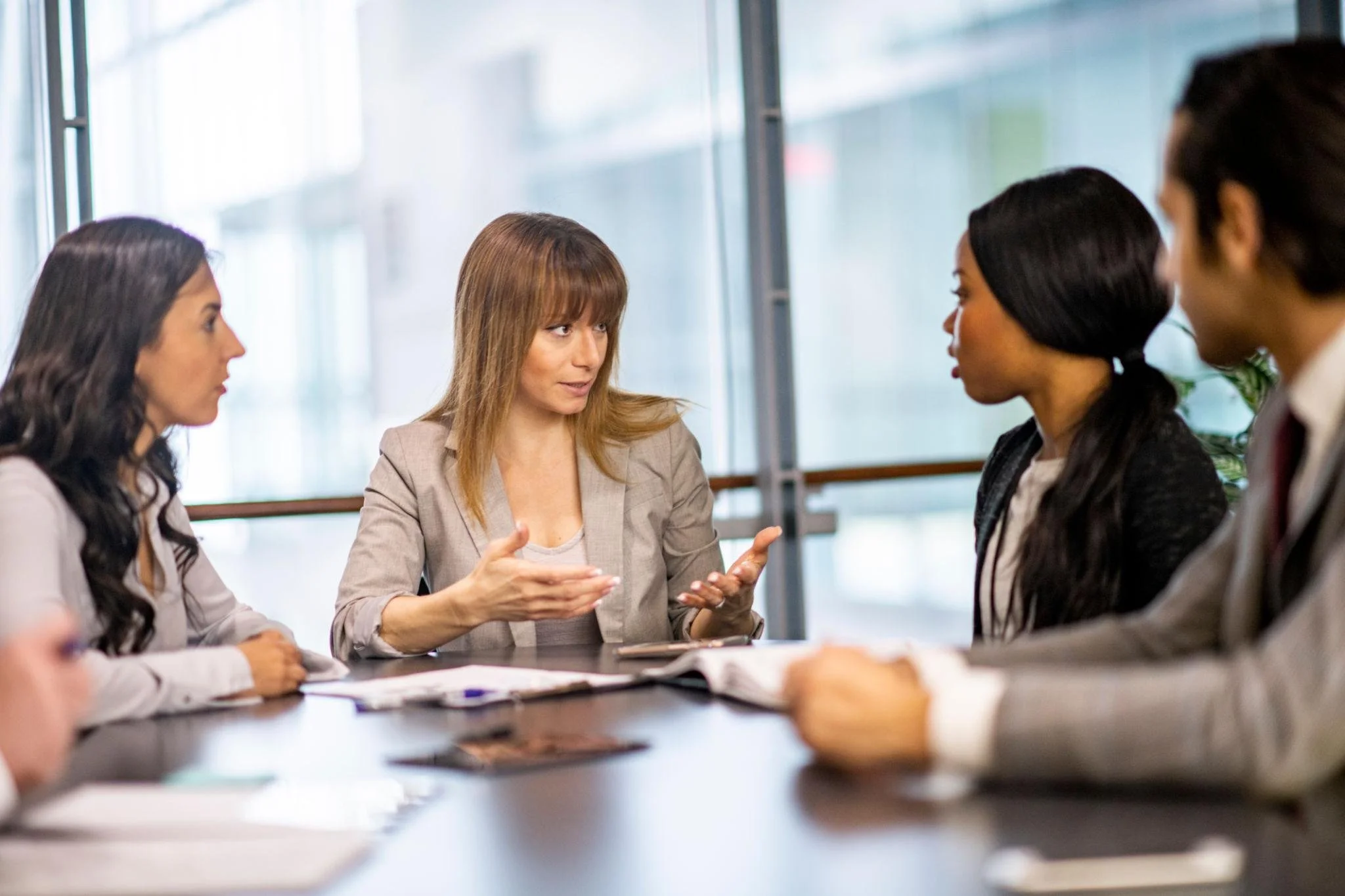 Manager speaking with employees in a professional office setting, representing leadership consistency, performance standards, and management accountability across teams.